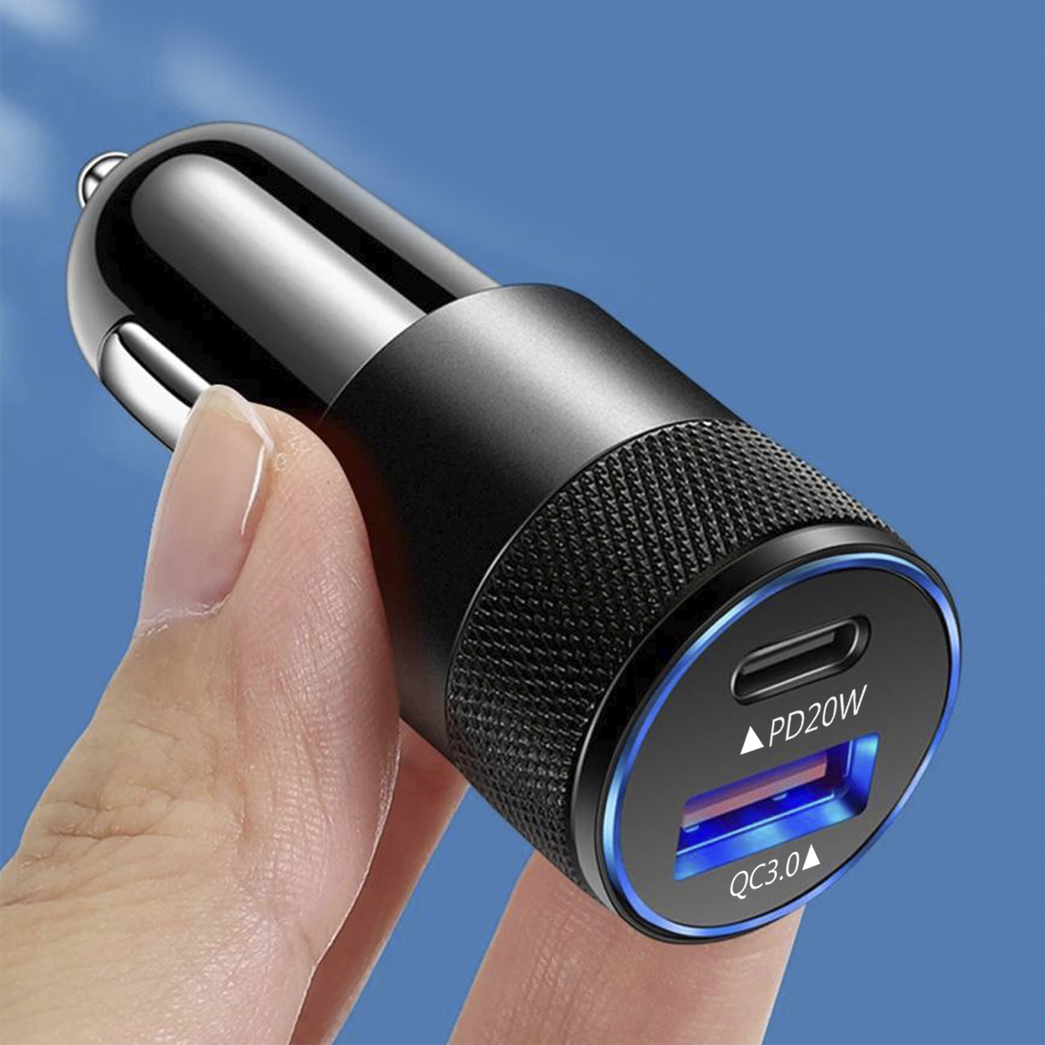 Caricatore per auto nero con luce blu intorno alle porte USB, tenuto in mano.