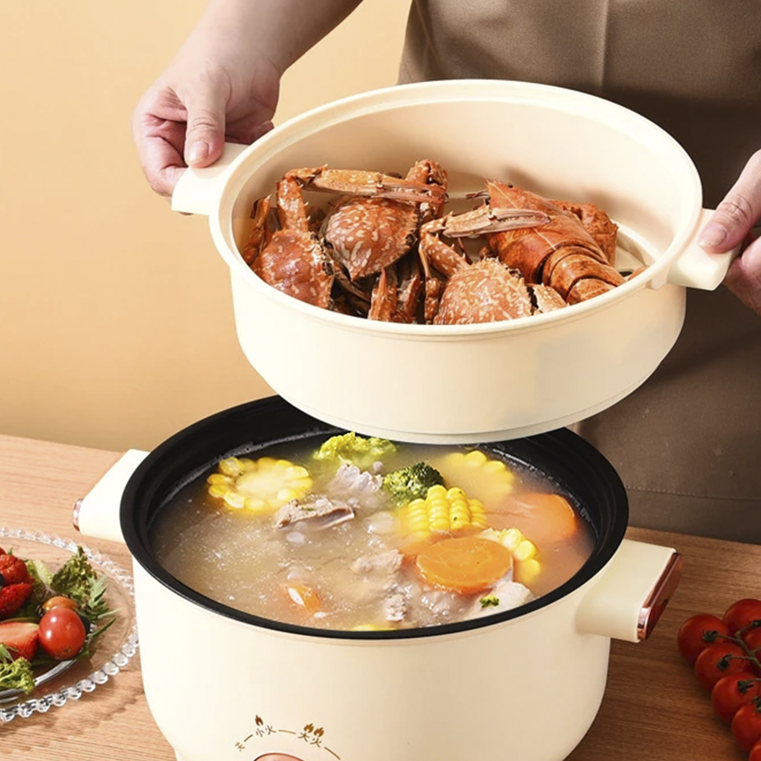 Una olla con comida cocinada dentro de otra olla. La olla superior tiene cangrejos.