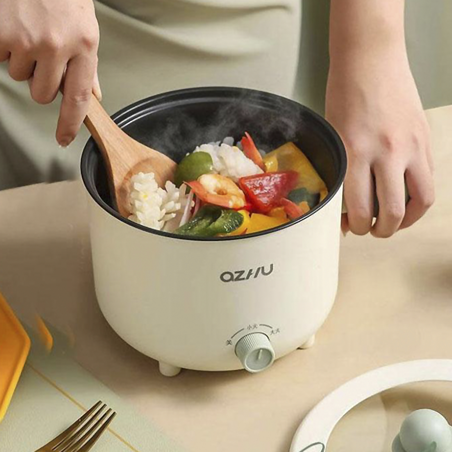 Una piccola pentola di cibo che viene cucinato con un cucchiaio di legno. Verdure e riso visibili.
