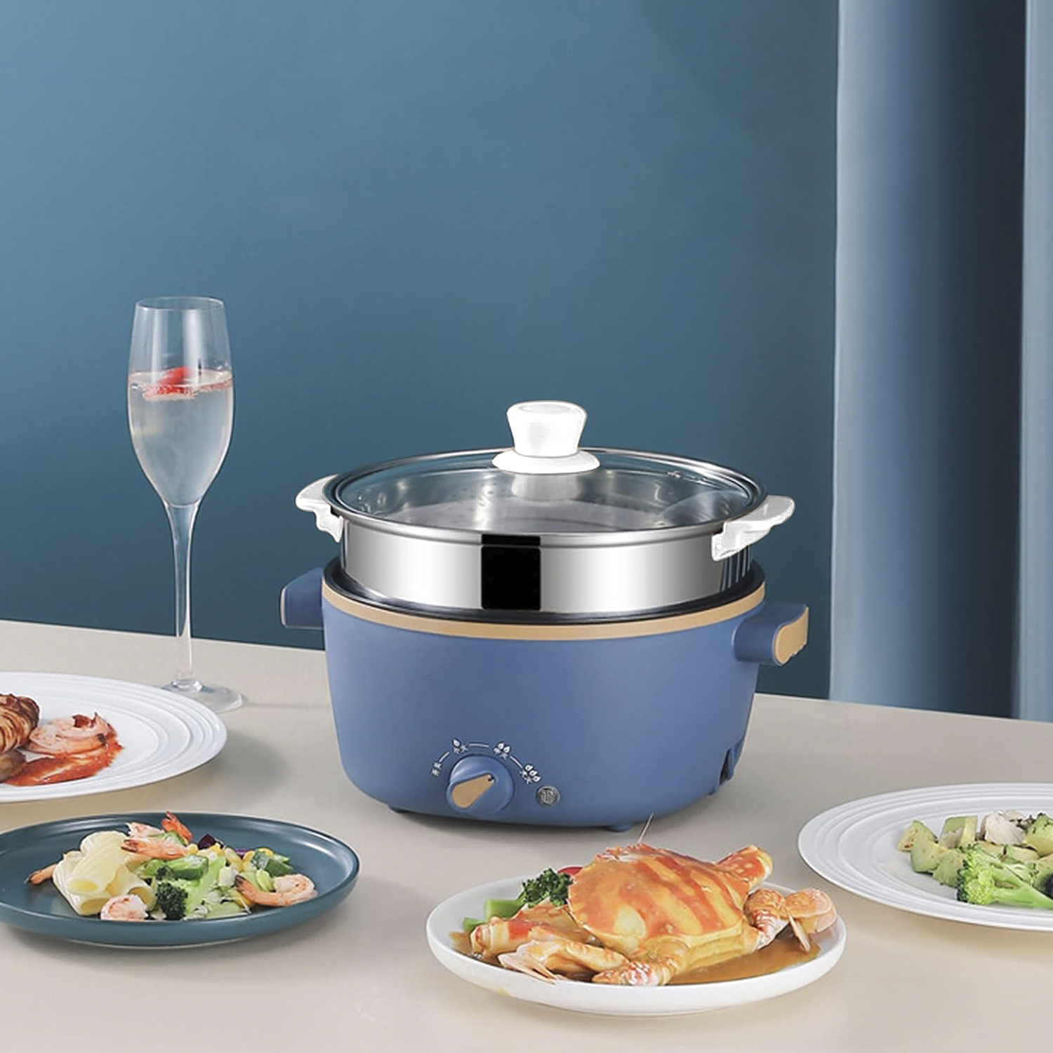 Vaporera azul y dorada de varios niveles con platos de comida y un vaso de agua en una mesa.