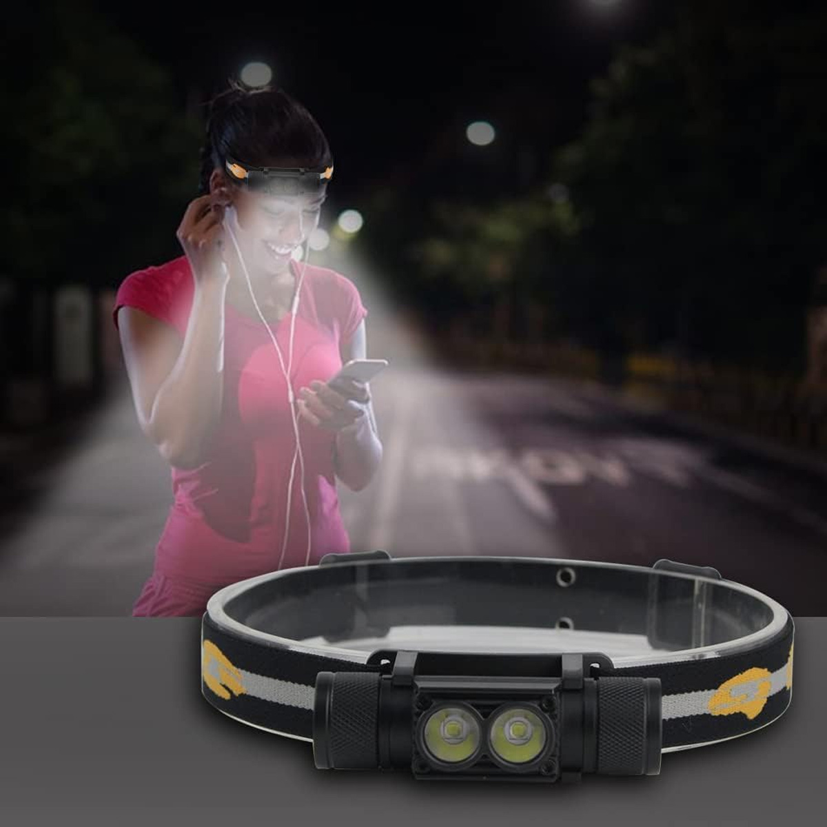 Frau in rosa Hemd, die eine Stirnlampe trägt, Musik hört und nachts auf einer Straße auf ihr Handy schaut.