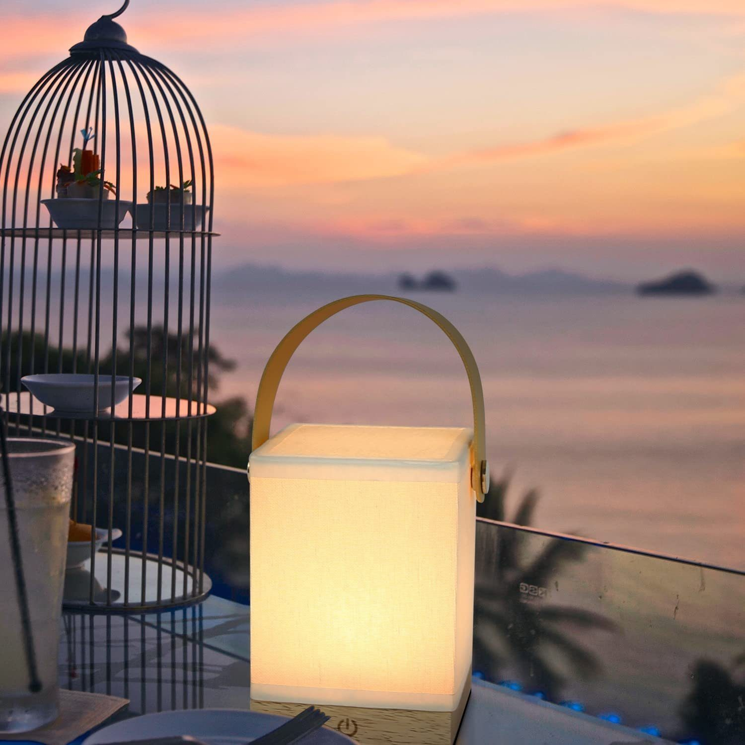 Zapalone światło na stole z widokiem na ocean o zachodzie słońca. Klatka po lewej.