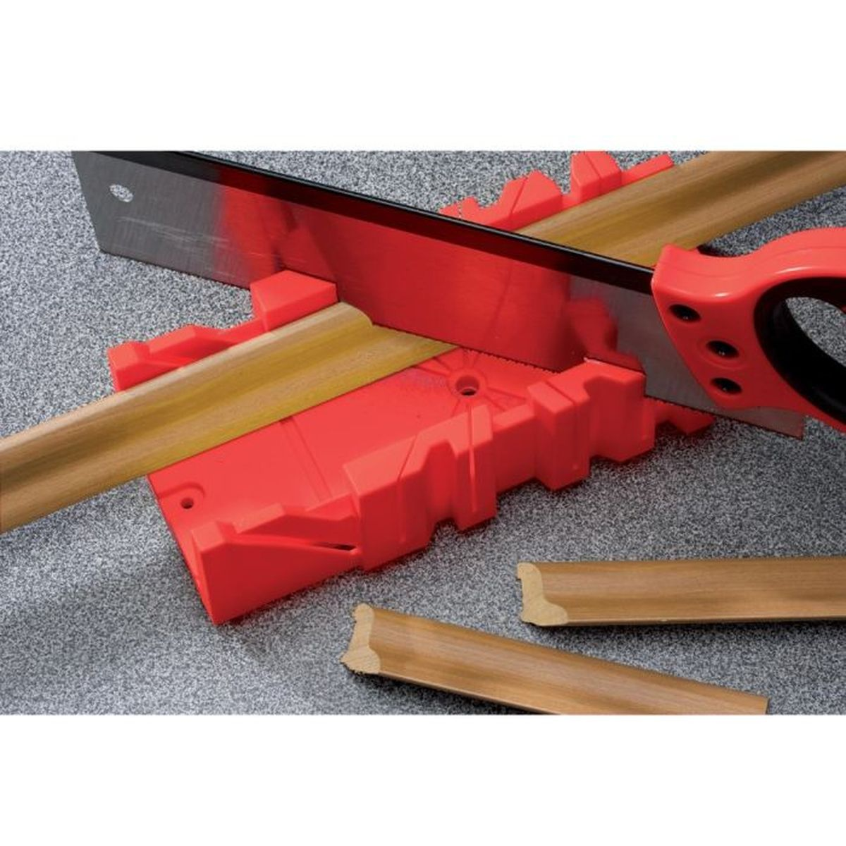 Rote Gehrungslade mit einem braunen Holzstück, das von einer Säge geschnitten wird.