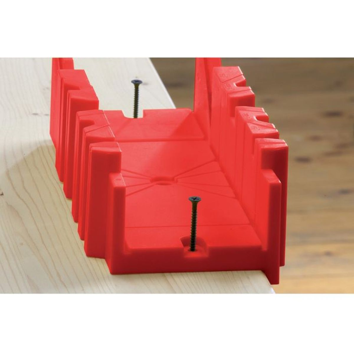 Rote Gehrungslade mit zwei Schrauben, auf Holz stehend. Die Box hat einen V-förmigen Kanal.