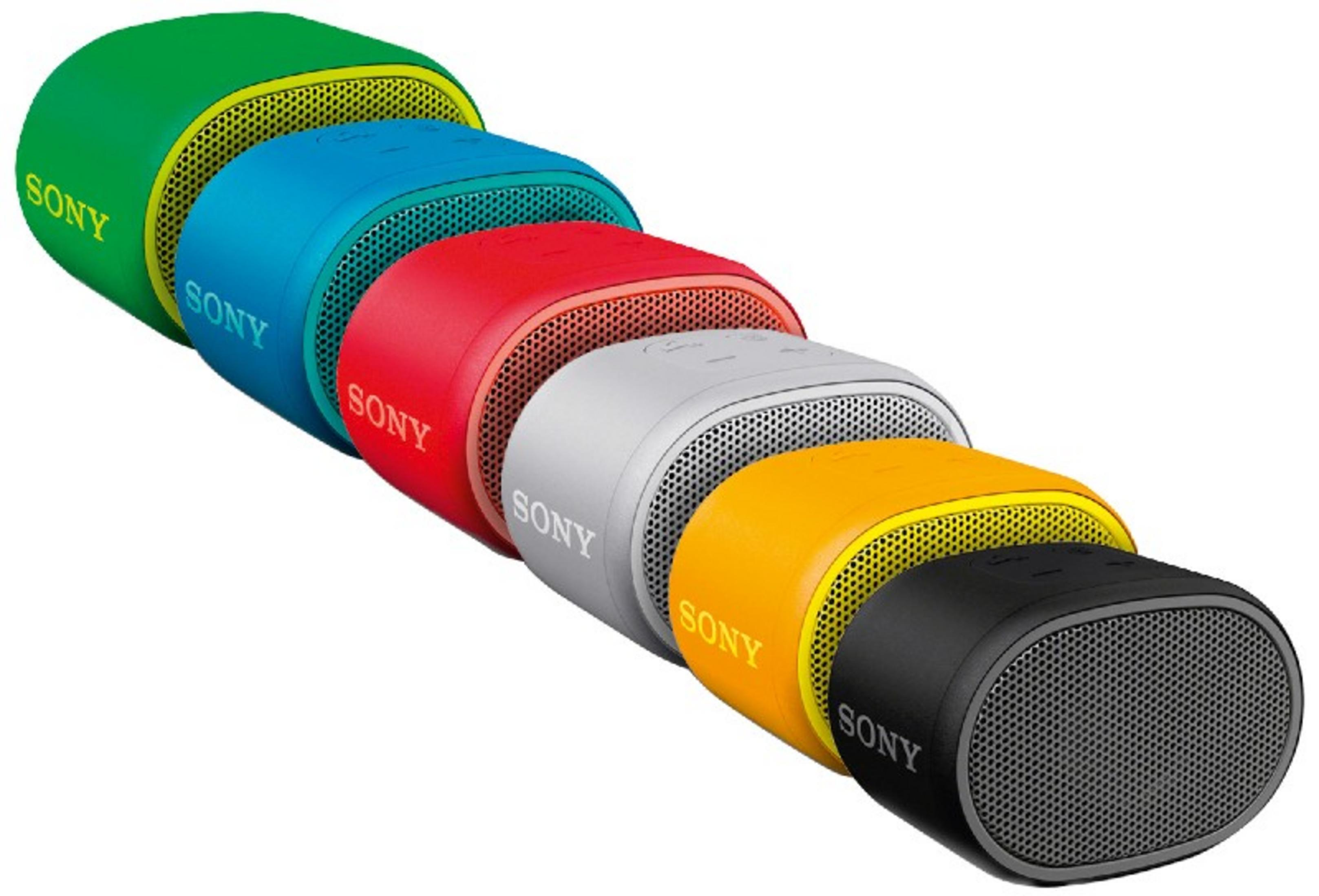 Altavoces en fila. Verde, azul, turquesa, rojo, gris, amarillo y negro. Fondo blanco.