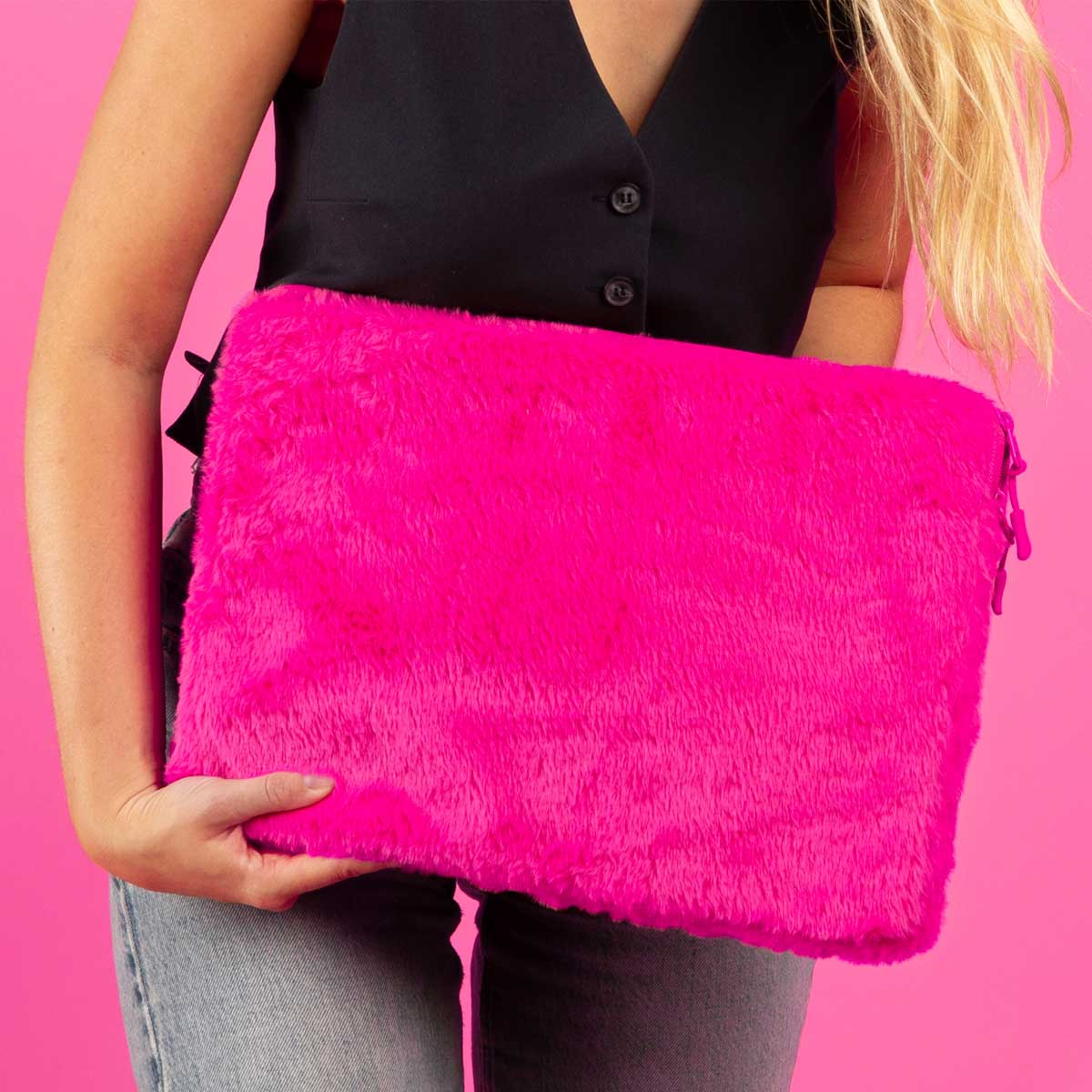 Woman holding a bright pink fluffy laptop sleeve.