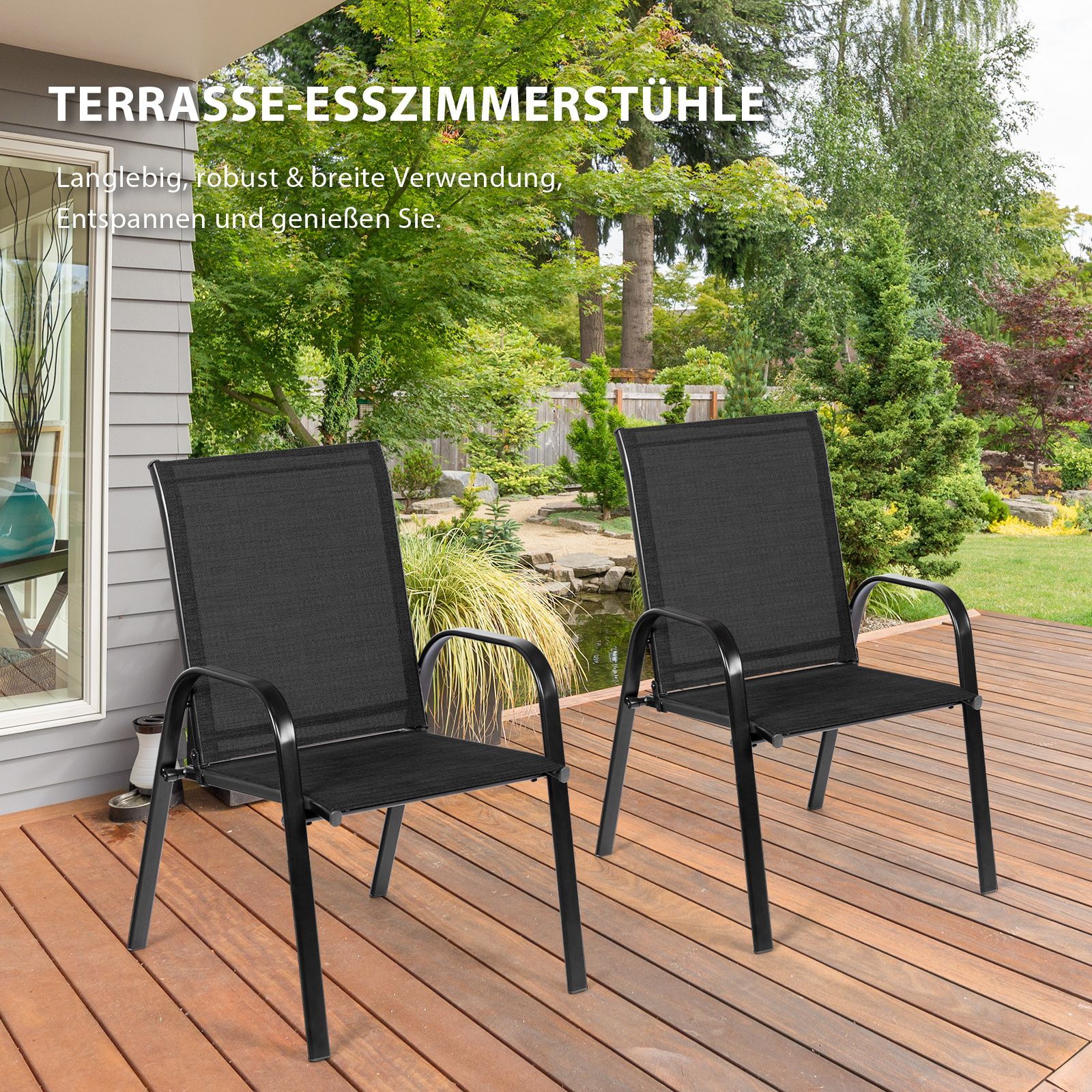 Zwei schwarze Stühle im Freien auf einer Holzterrasse, mit einem Haus und Bäumen im Hintergrund.