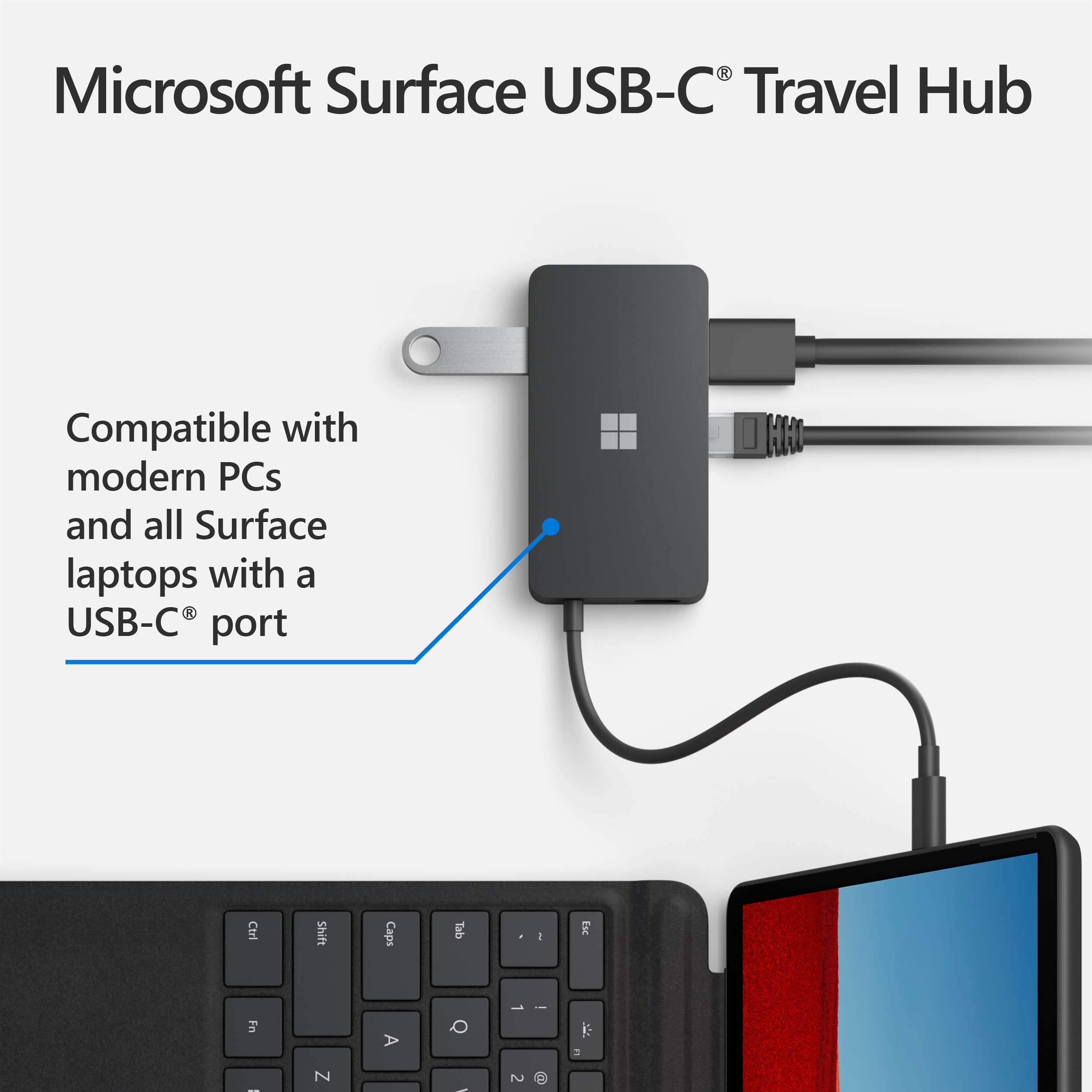 Hub da viaggio USB-C nero collegato a un laptop e a una tastiera.