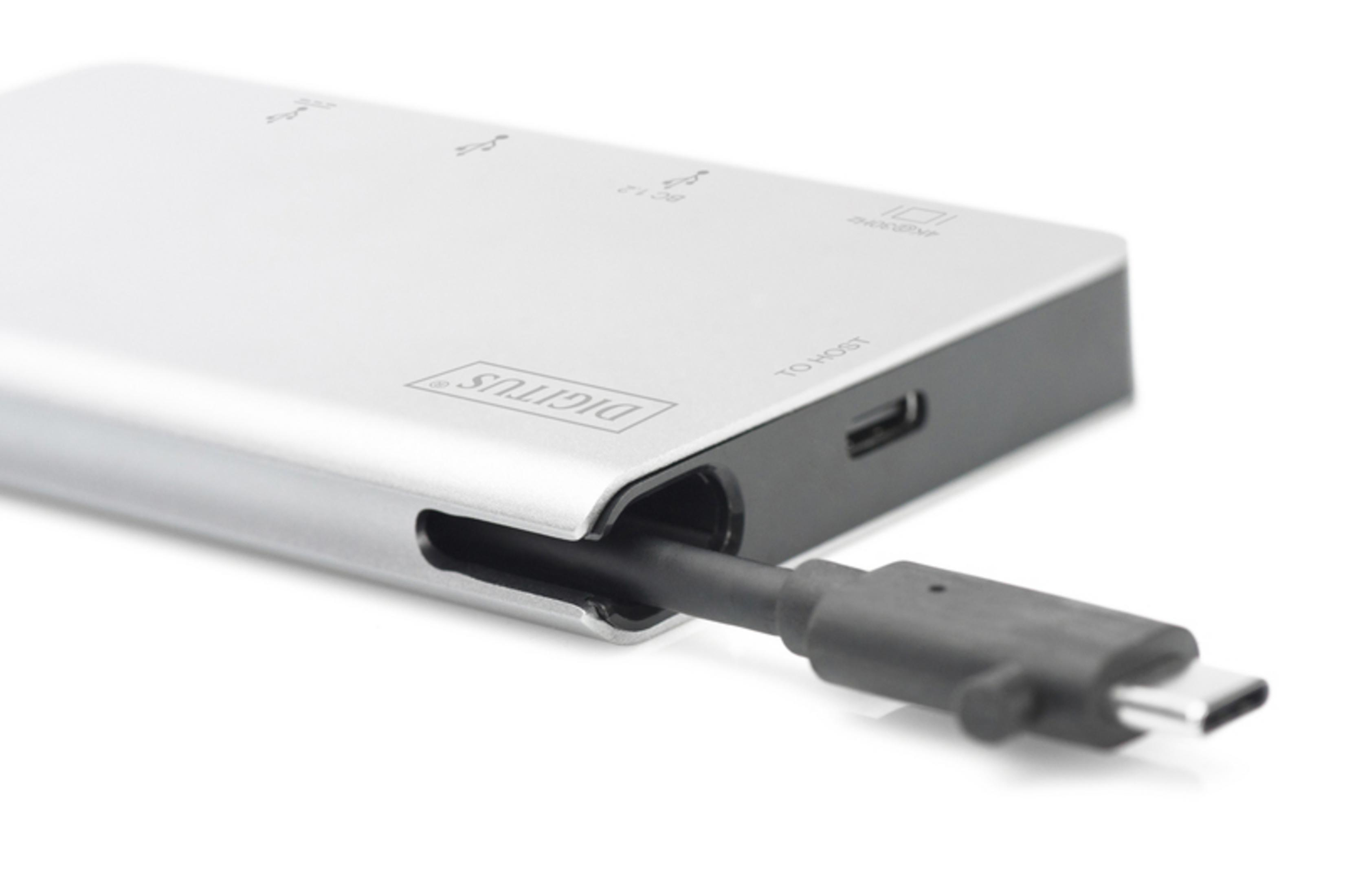 Dispositivo argentato con porte USB. Un cavo nero è collegato a una porta USB-C.