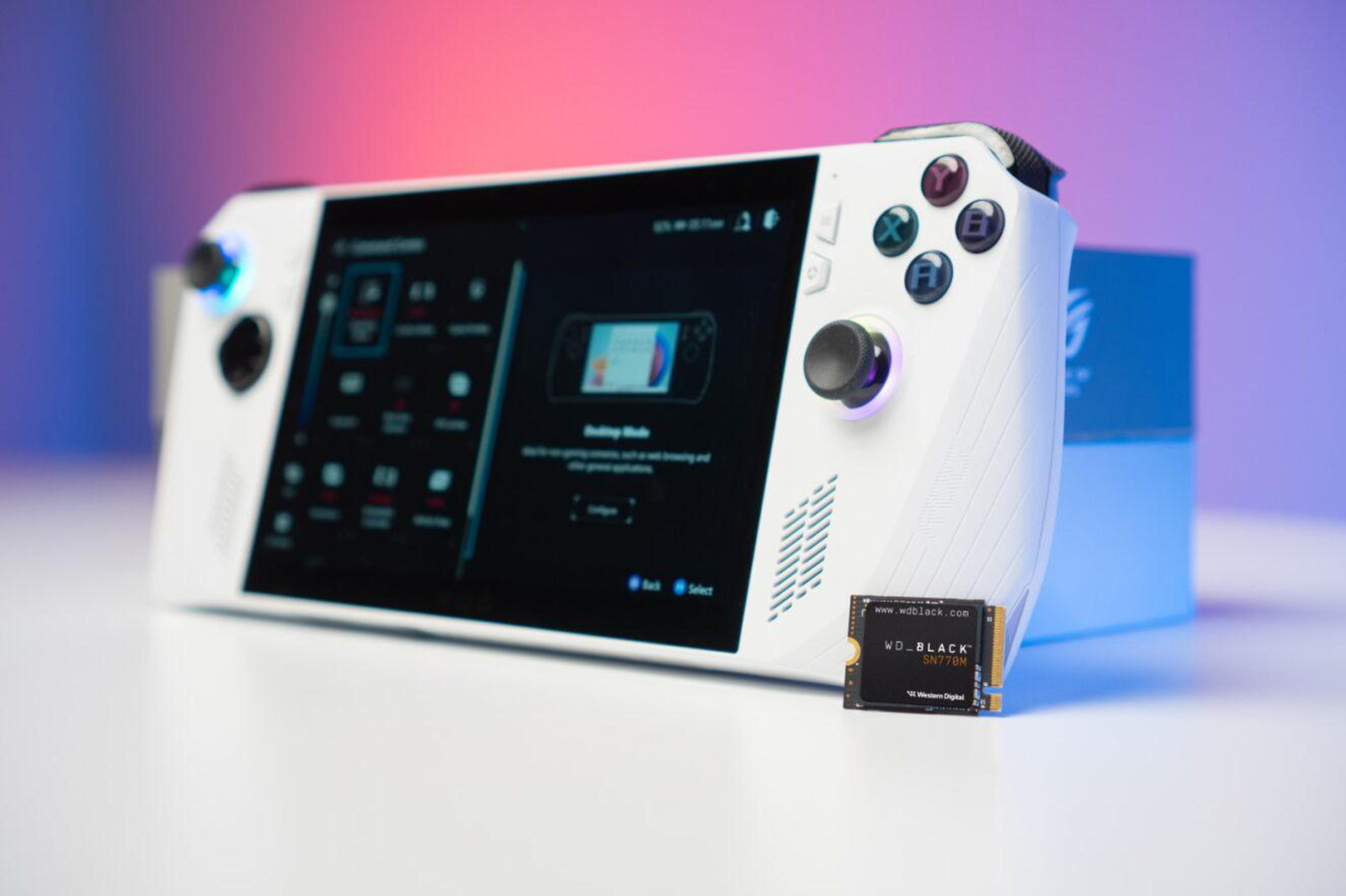 Biało-czarna konsola do gier z ekranem i kontrolerami, mały dysk SSD obok.