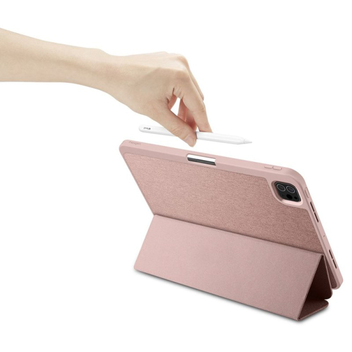 Hand placing a pen near a pink tablet with an attached cover.