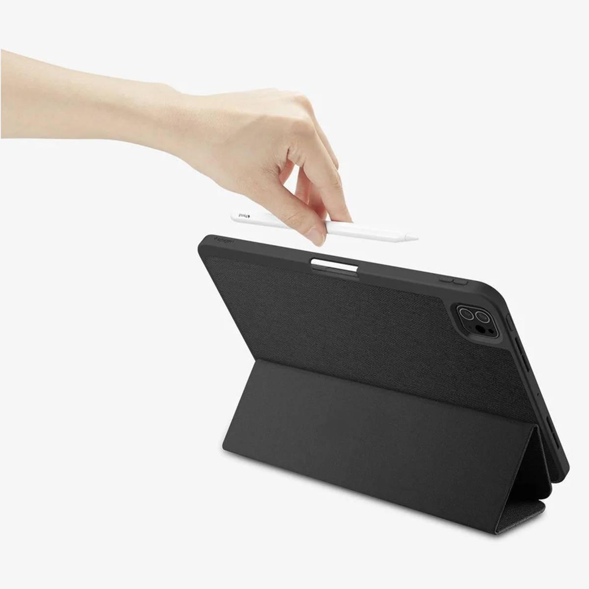 Hand placing a white stylus on a black tablet in a black case. White background.