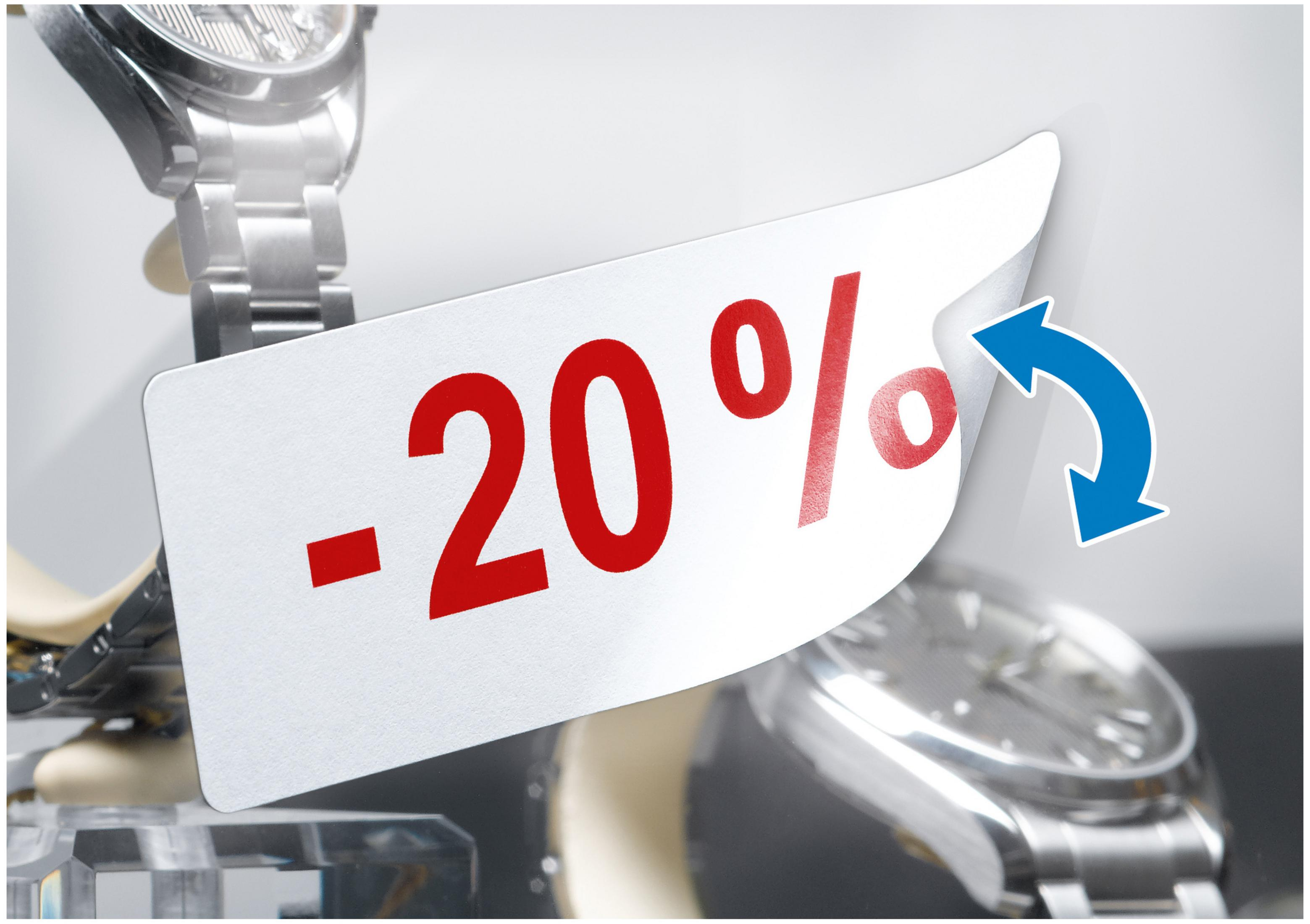 Ein weißes Etikett mit rotem -20% Text, mit einem gebogenen Pfeil und dem Hintergrund mit Uhren.