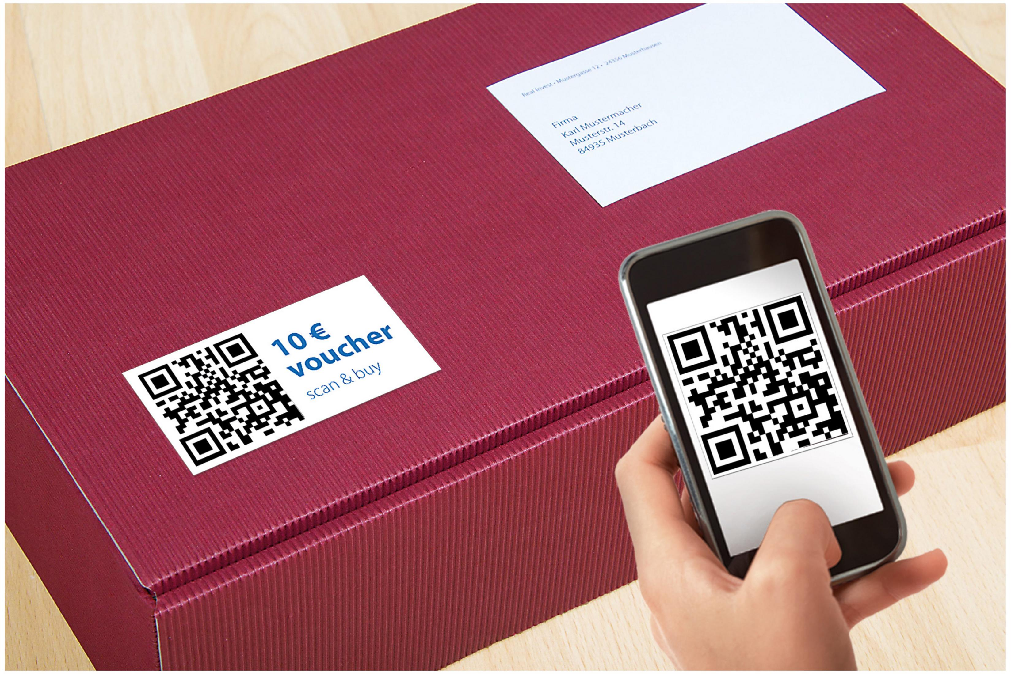 Eine weinrote Geschenkbox mit einem QR-Code-Aufkleber und ein Telefon, das einen QR-Code scannt.