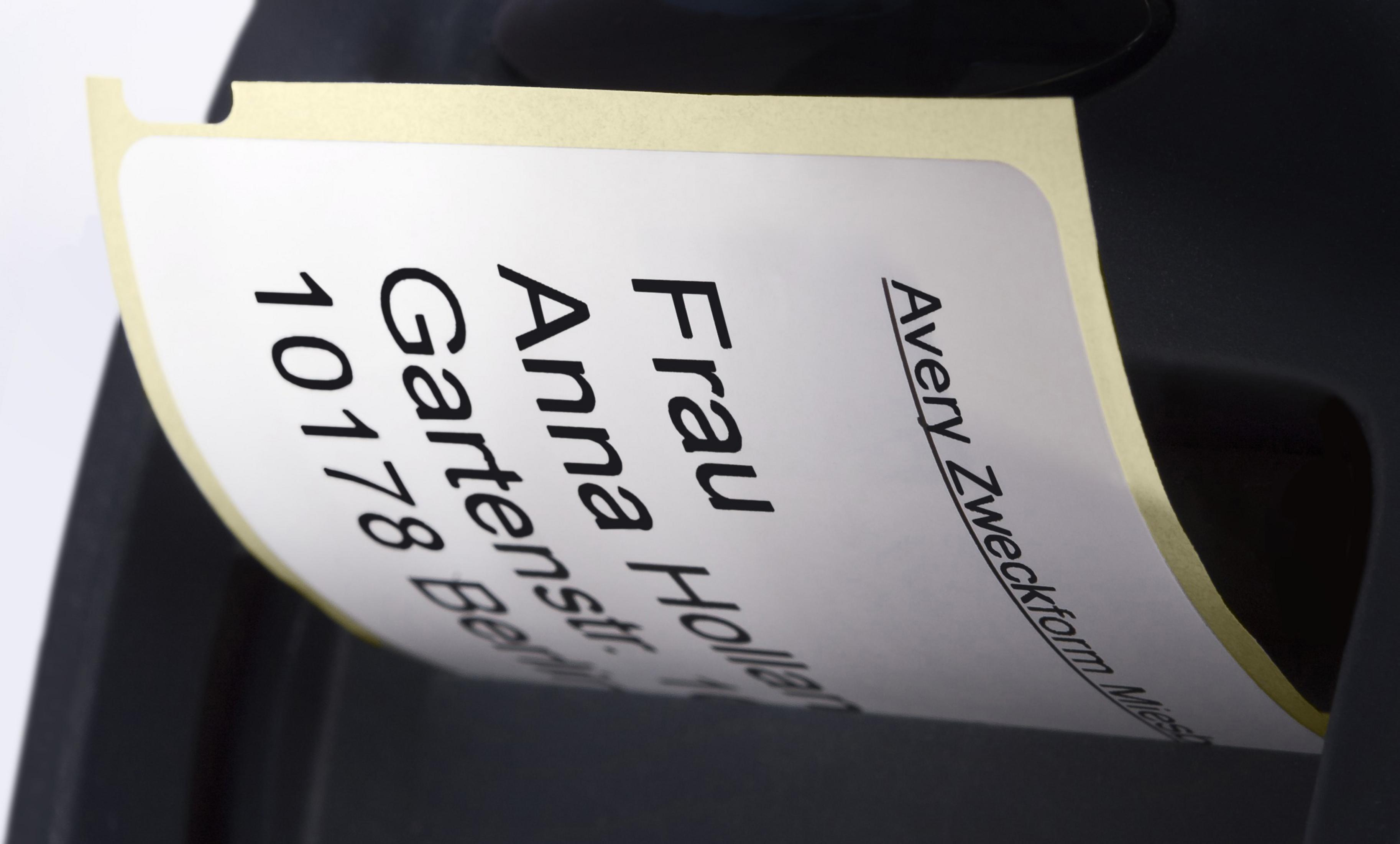 Weißes Etikett mit schwarzem Text. Etikett enthält Name und Adresse.