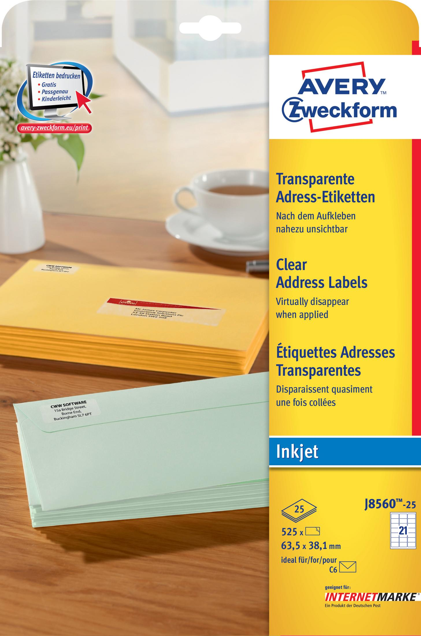 Avery-Adressetiketten, gelbe und grüne Umschläge und eine Tasse auf einer weißen Oberfläche.