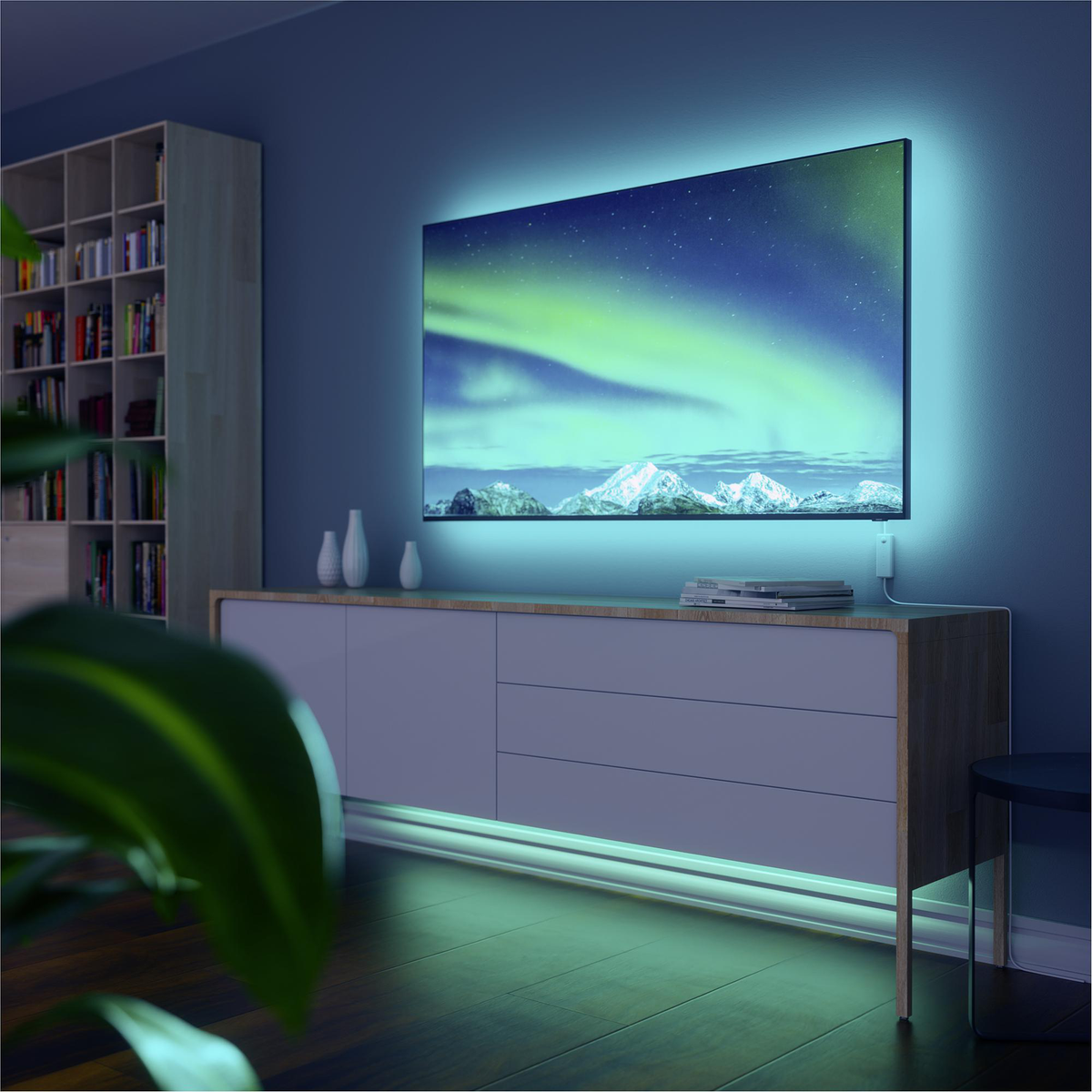 Fernseher auf einem Schrank mit Umgebungsbeleuchtung. Szene hat ein modernes, gemütliches, blaues Interieur.