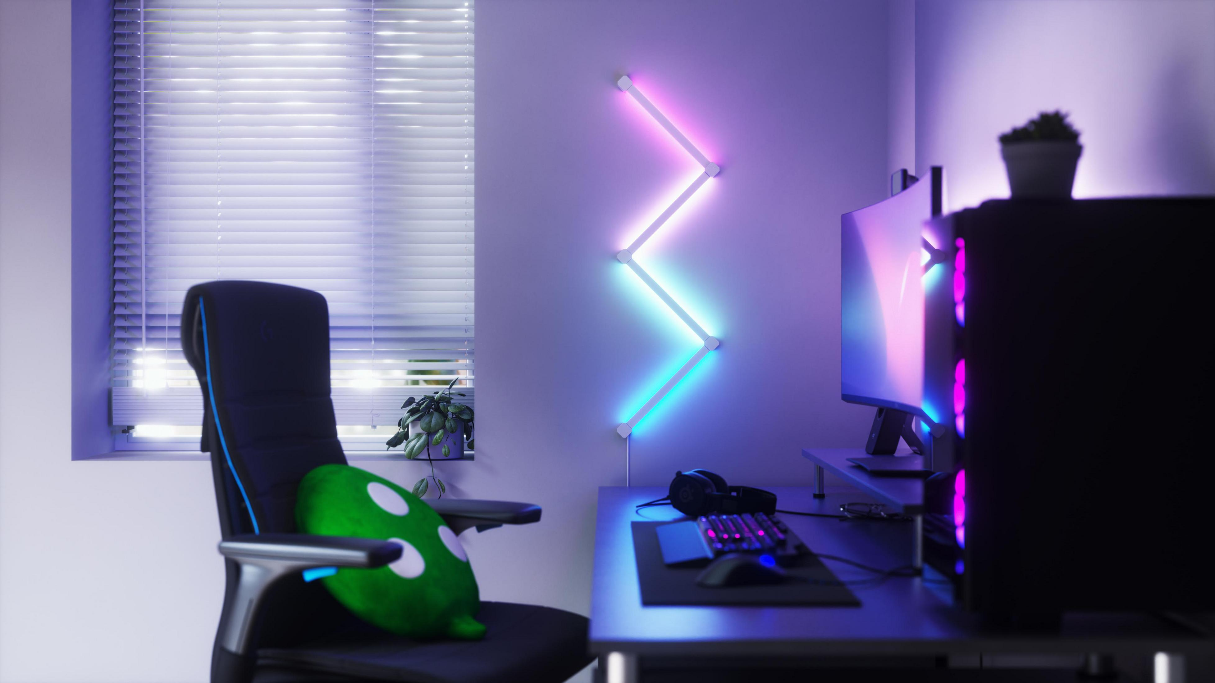 Un setup da gaming con monitor, tastiera e una luce a LED montata a parete.