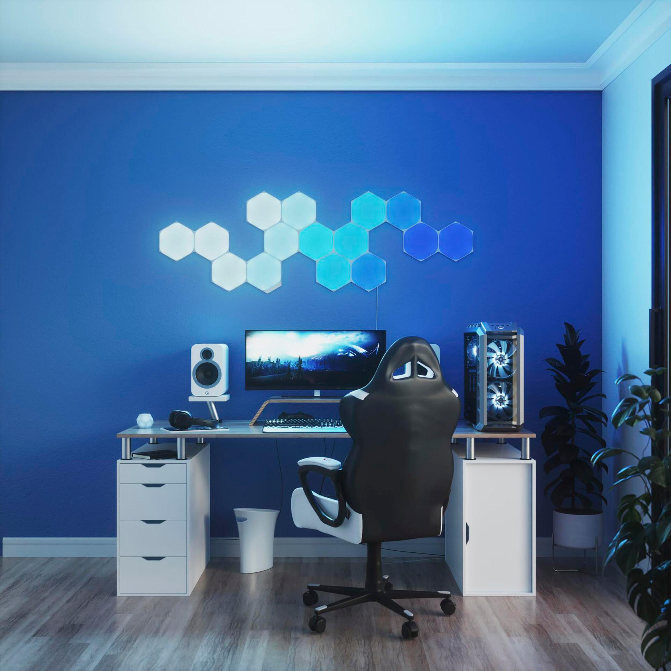 Un'impostazione di gioco in una stanza illuminata di blu. Include computer, monitor, sedia, altoparlanti e luci a LED.