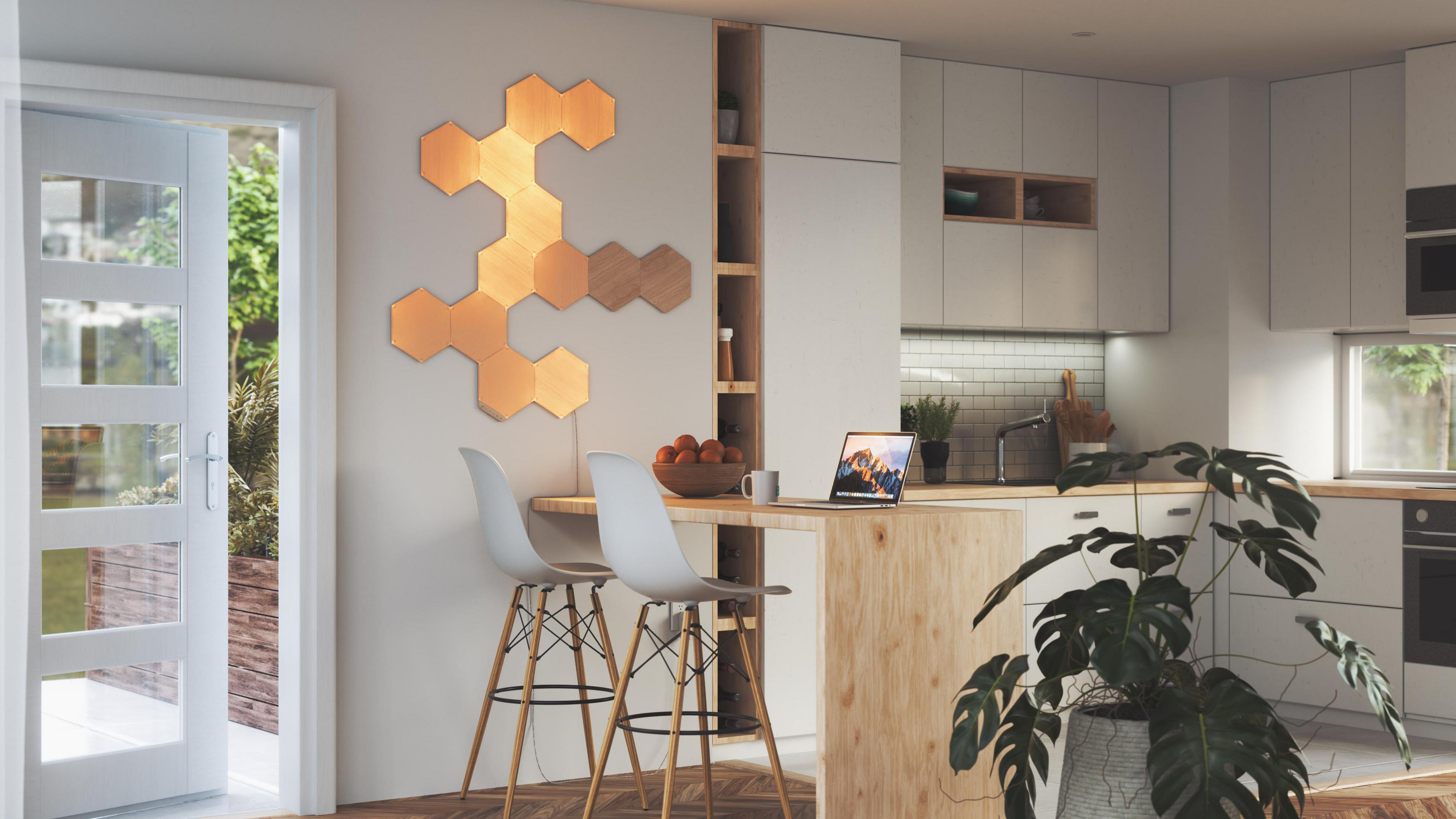 Cucina moderna con isola in legno, piante e decorazione a parete a nido d'ape.