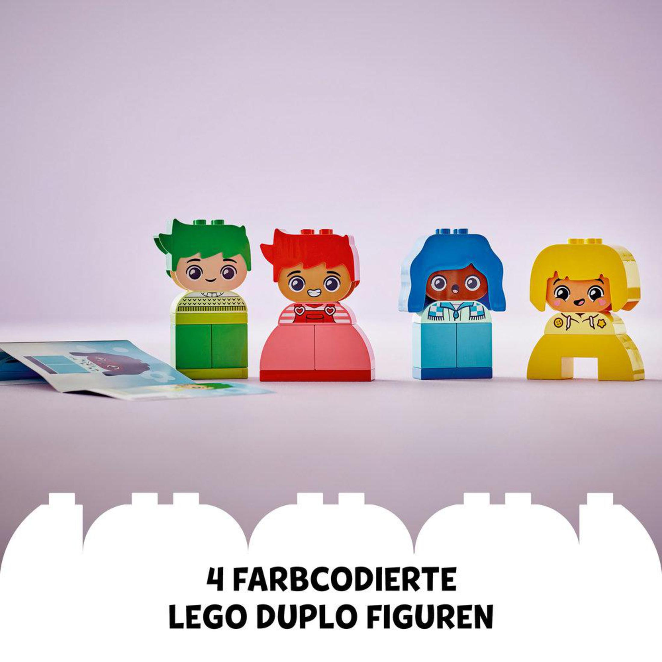 Cztery figurki Lego Duplo w różnych kolorach. Obok otwarta książka.