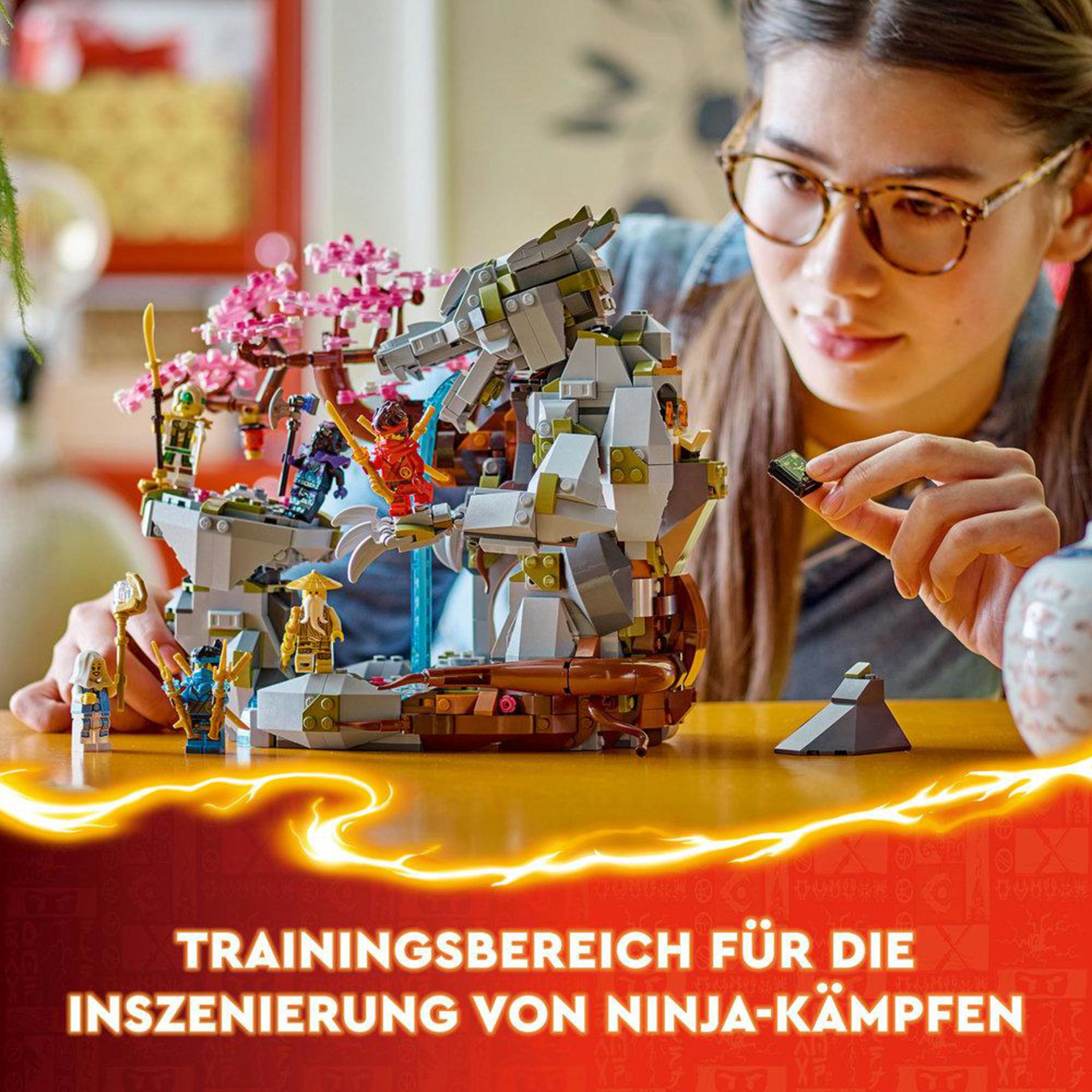 Ein Mädchen mit Brille spielt mit einem Lego-Set. Das Set zeigt eine Ninja-Szene.