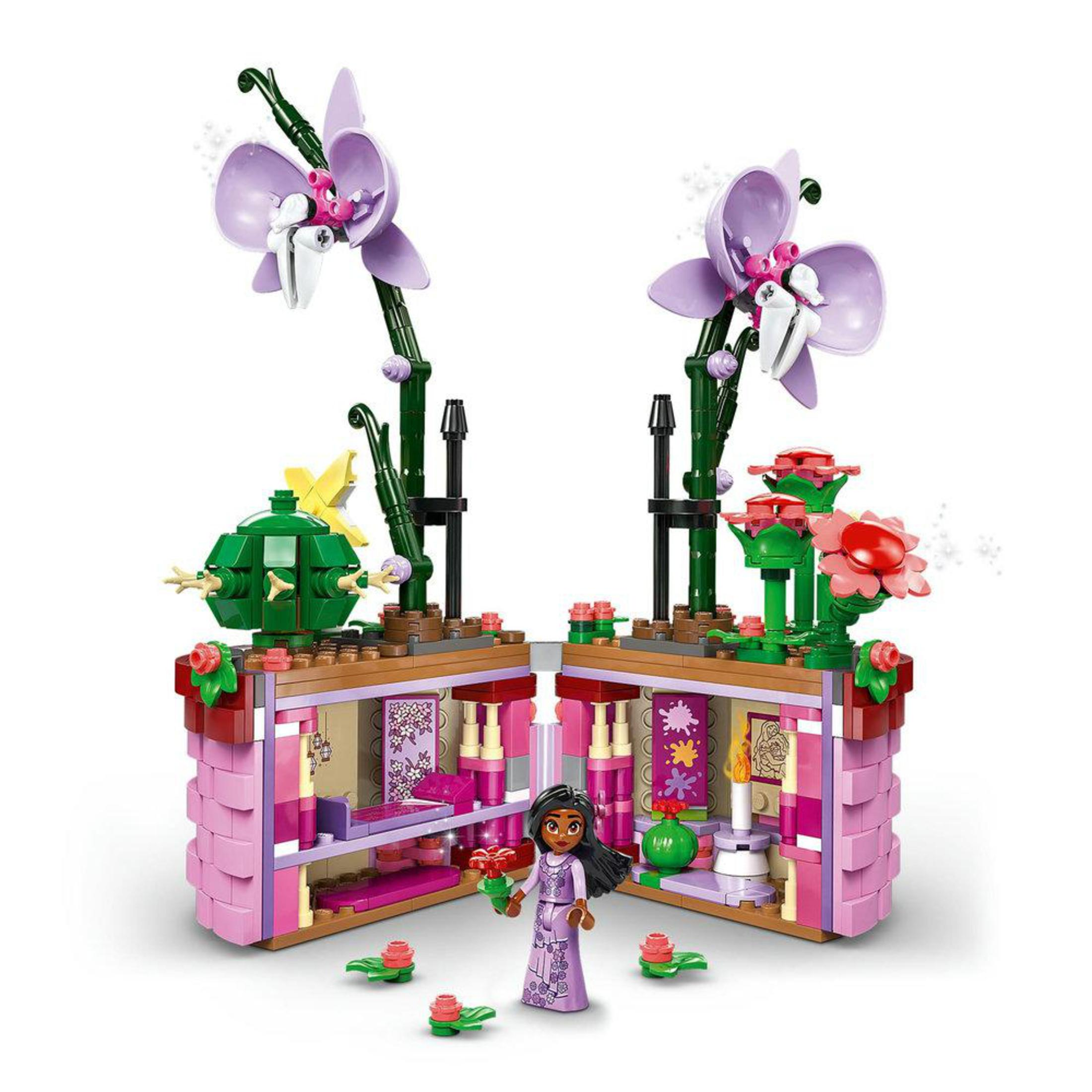 Un set Lego con una bambola Lego, fiori e un edificio in rosa e viola.