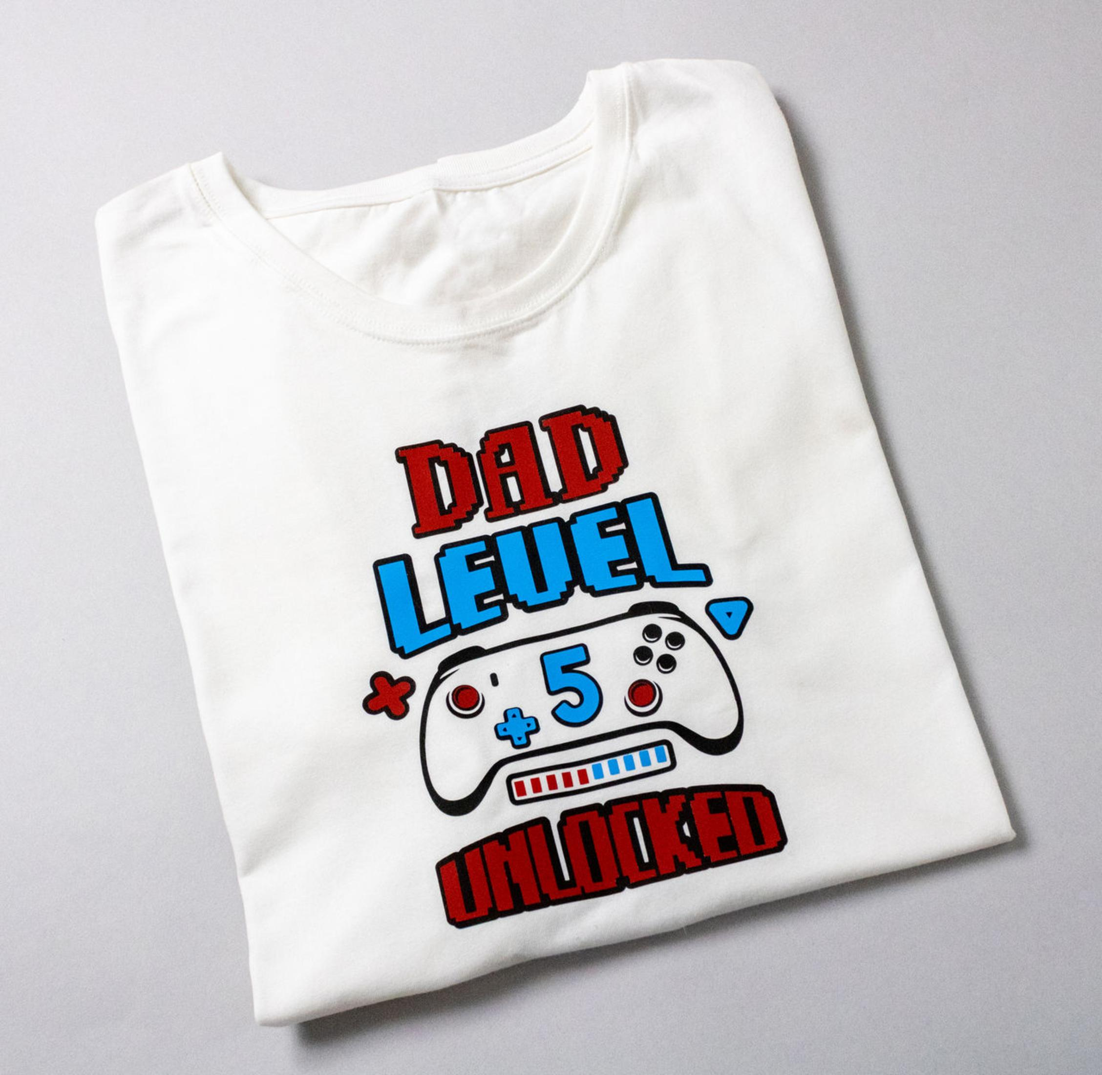 Weißes T-Shirt mit Gaming-Controller-Design: DAD LEVEL +5 UNLOCKED.