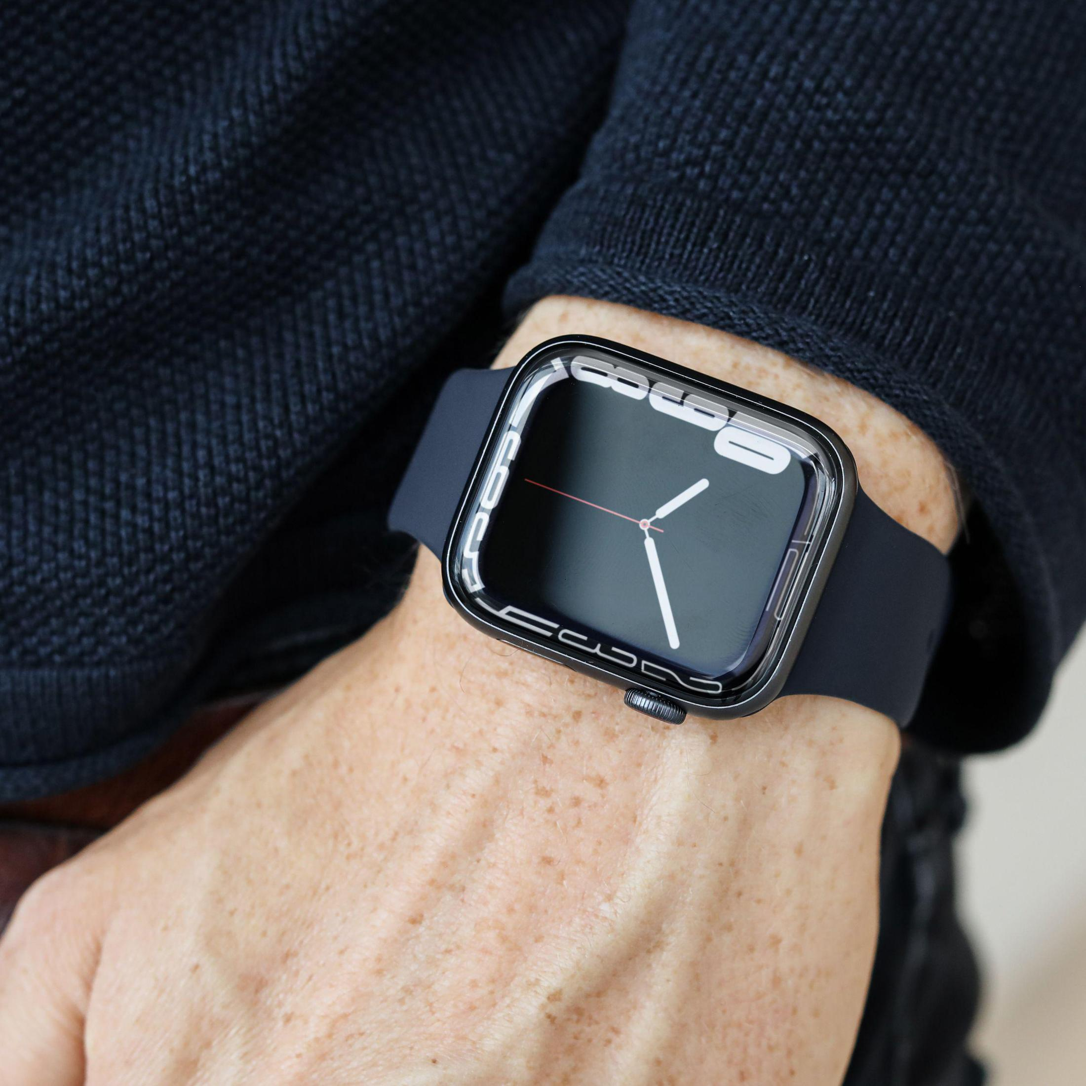 Eine Person, die eine Smartwatch mit dunkelblauem Band trägt. Die Uhr hat einen schwarzen Bildschirm.