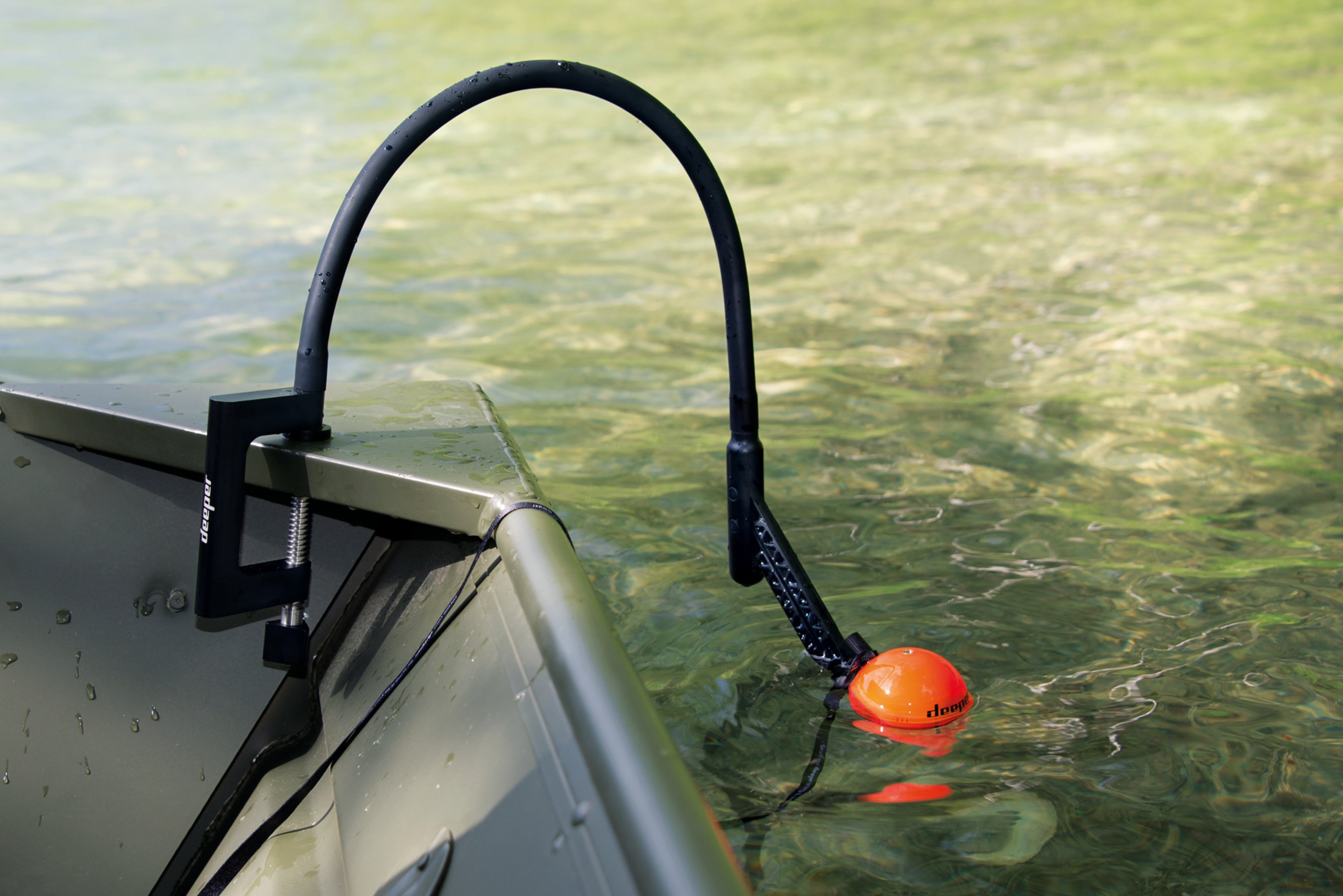 Fischsonar-Gerät an einem Boot montiert. Schwarzes und oranges Gerät im Wasser. Boot und Wasser sichtbar.