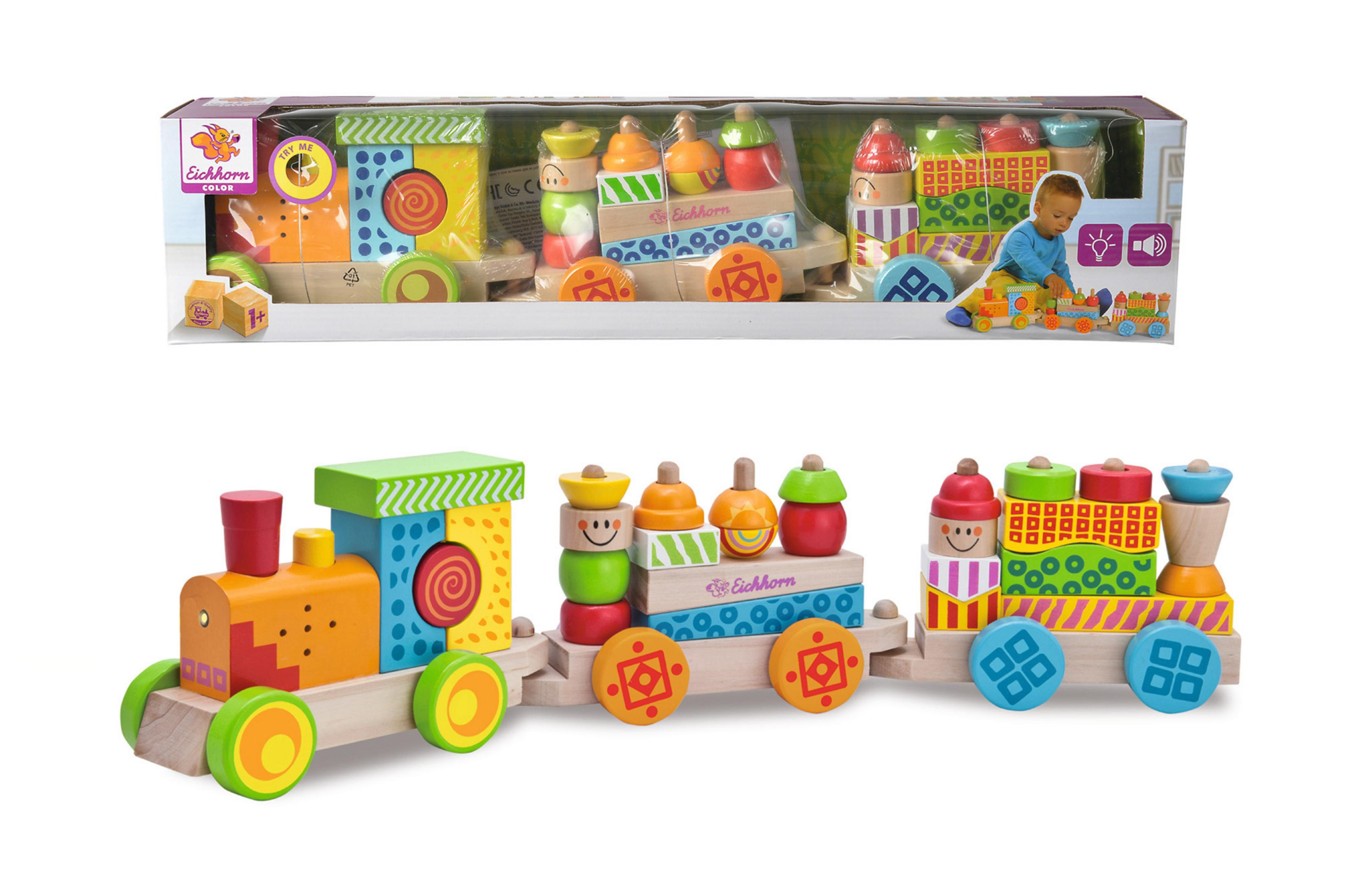 Holzeisenbahn mit Wagen und Blöcken, in einer Box, mit spielendem Kind.