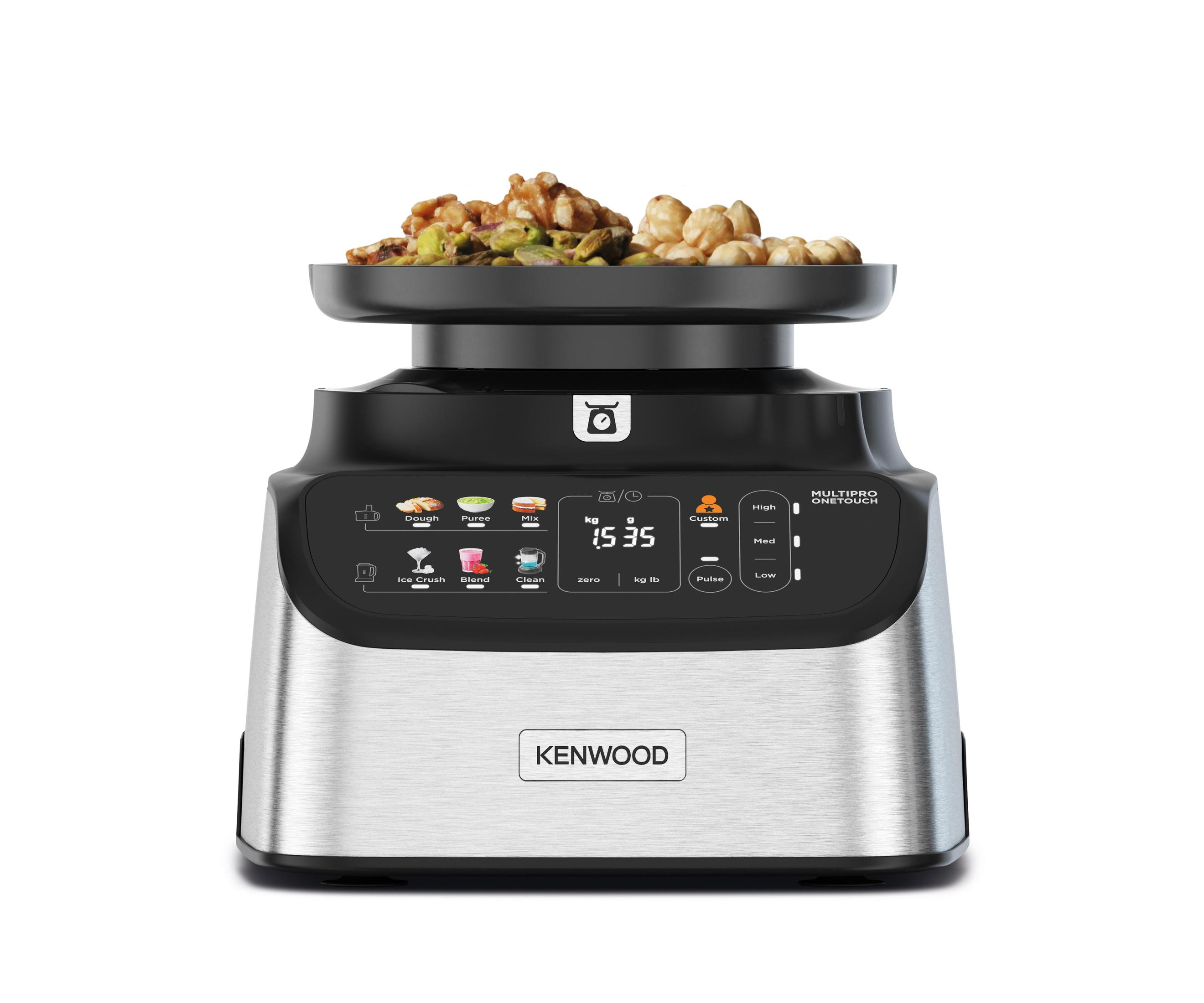 Zilveren en zwarte Kenwood keukenmachine met voedsel bovenop en een digitaal display.