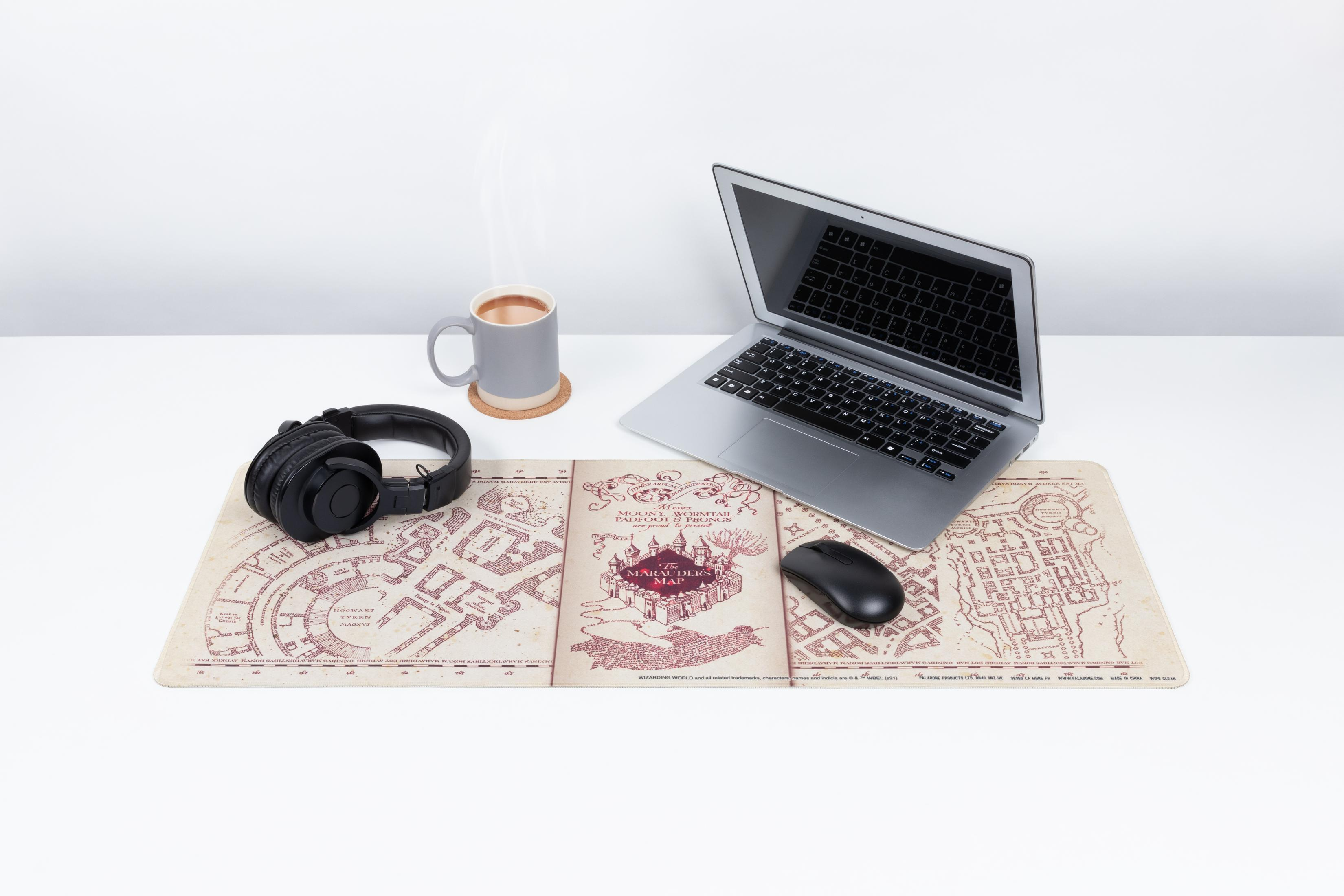 Laptop, Kopfhörer und eine Tasse auf einem Schreibtisch mit Mauspad.