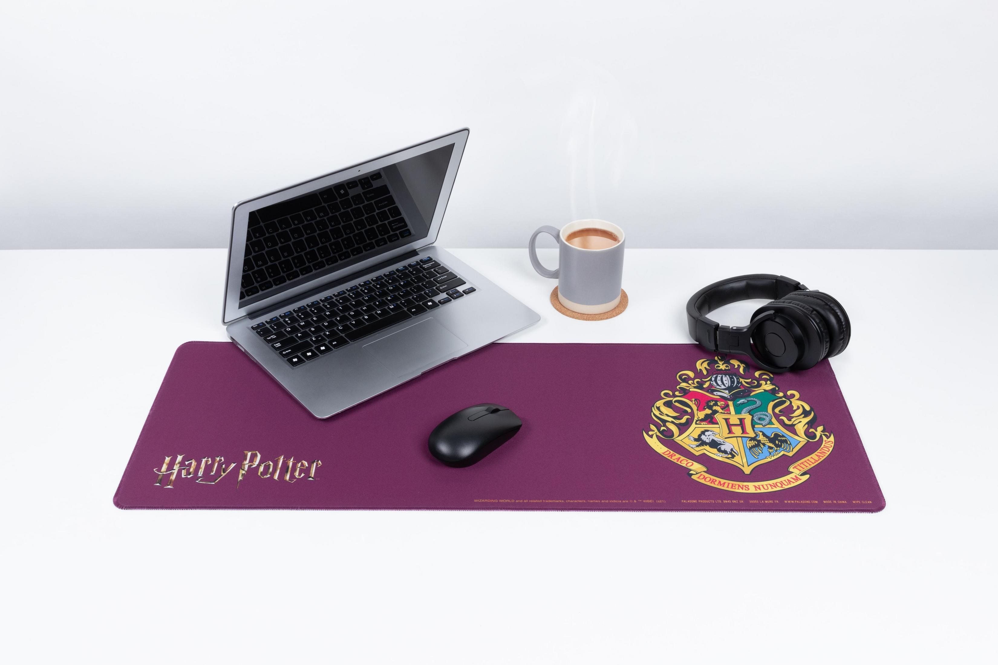 Ein Laptop, eine Tasse, Kopfhörer und eine Maus auf einem langen Harry Potter-Mauspad.