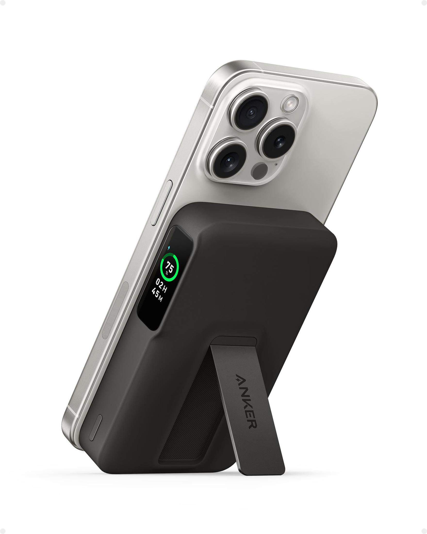 Zilveren telefoon met zwarte Anker powerbank. Powerbank is onder een hoek met een standaard. Witte achtergrond.