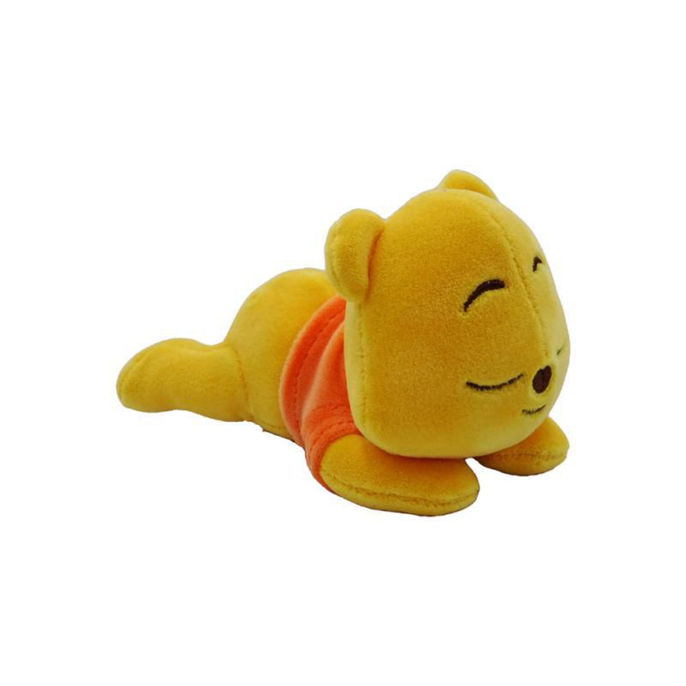 Ein gelbes Winnie-the-Pooh-Plüschtier, das liegt und ein orangefarbenes Hemd trägt.
