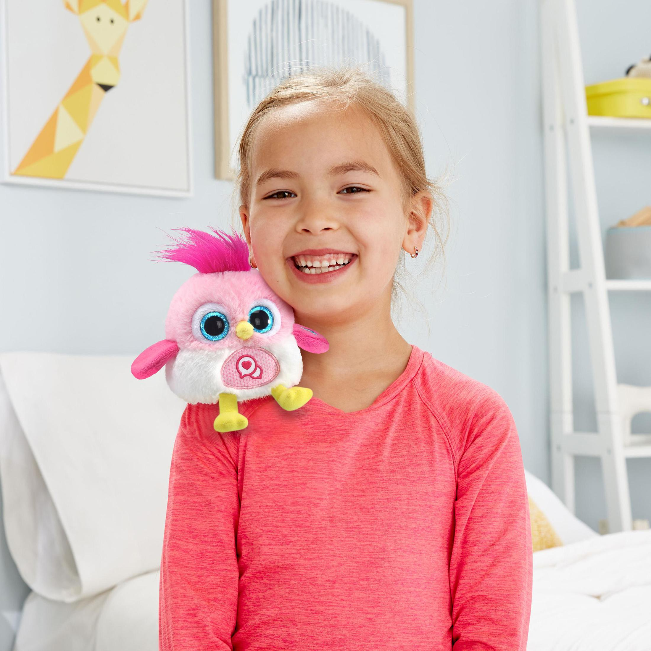Ein Mädchen lächelt und hält einen rosa Plüschvogel auf ihrer Schulter.