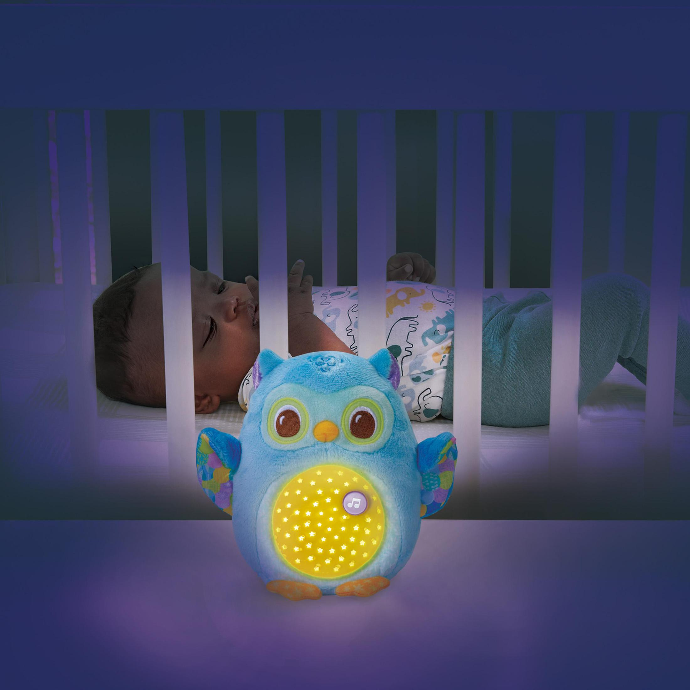 Ein Baby schläft in einem Kinderbett, neben einer Eulen-Nachtlicht mit sanftem Schein.
