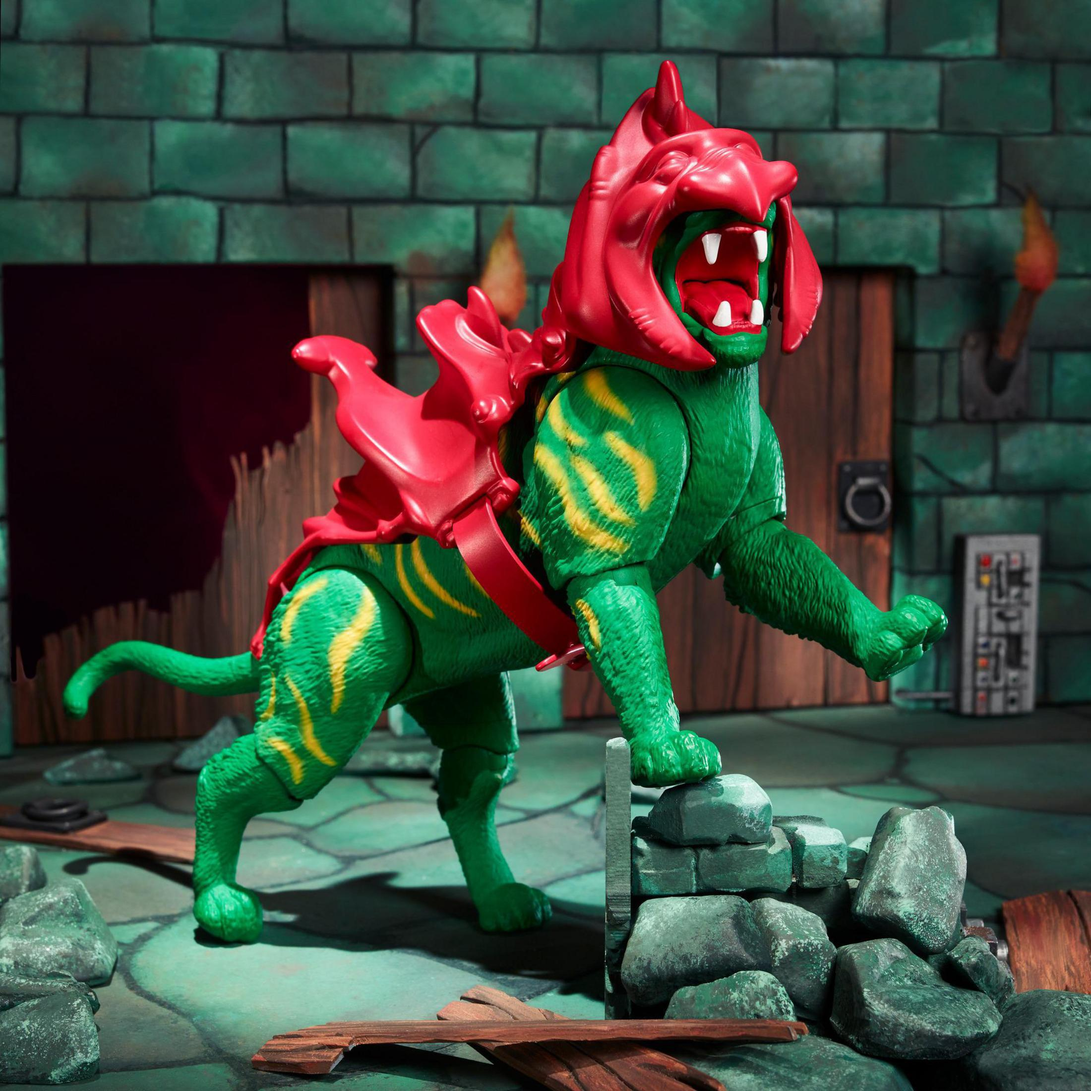 Eine grüne und rote Monsterkatze-Actionfigur in einer Steinumgebung.