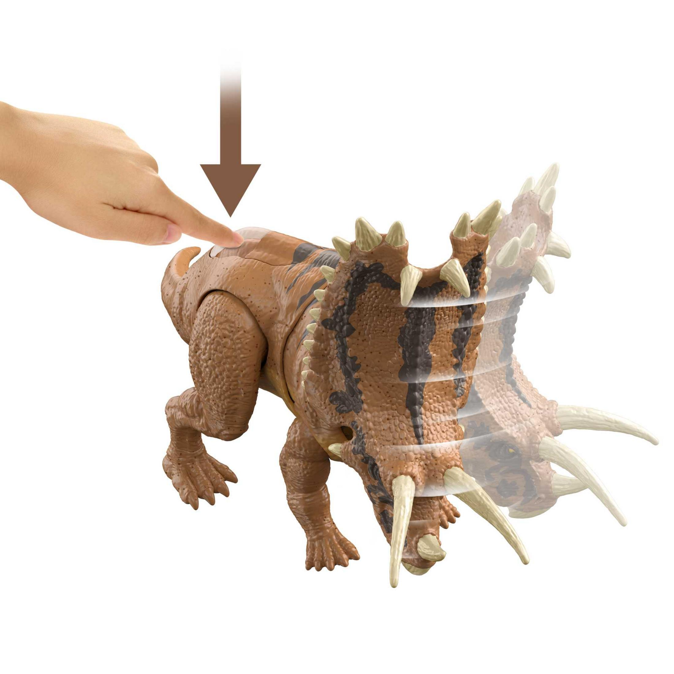 Eine Hand drückt einen Knopf auf einem braunen Dinosaurier-Spielzeug.