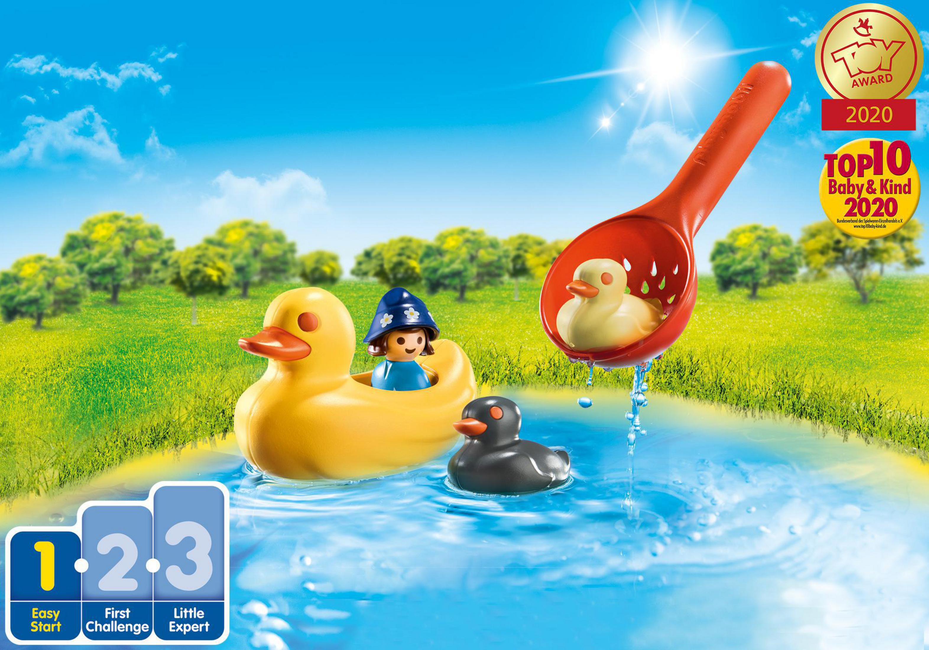 Eine Spielzeugszene mit einer Ente, einem kleinen Entchen in einer Schaufel und einem Kind in einem Entenboot.
