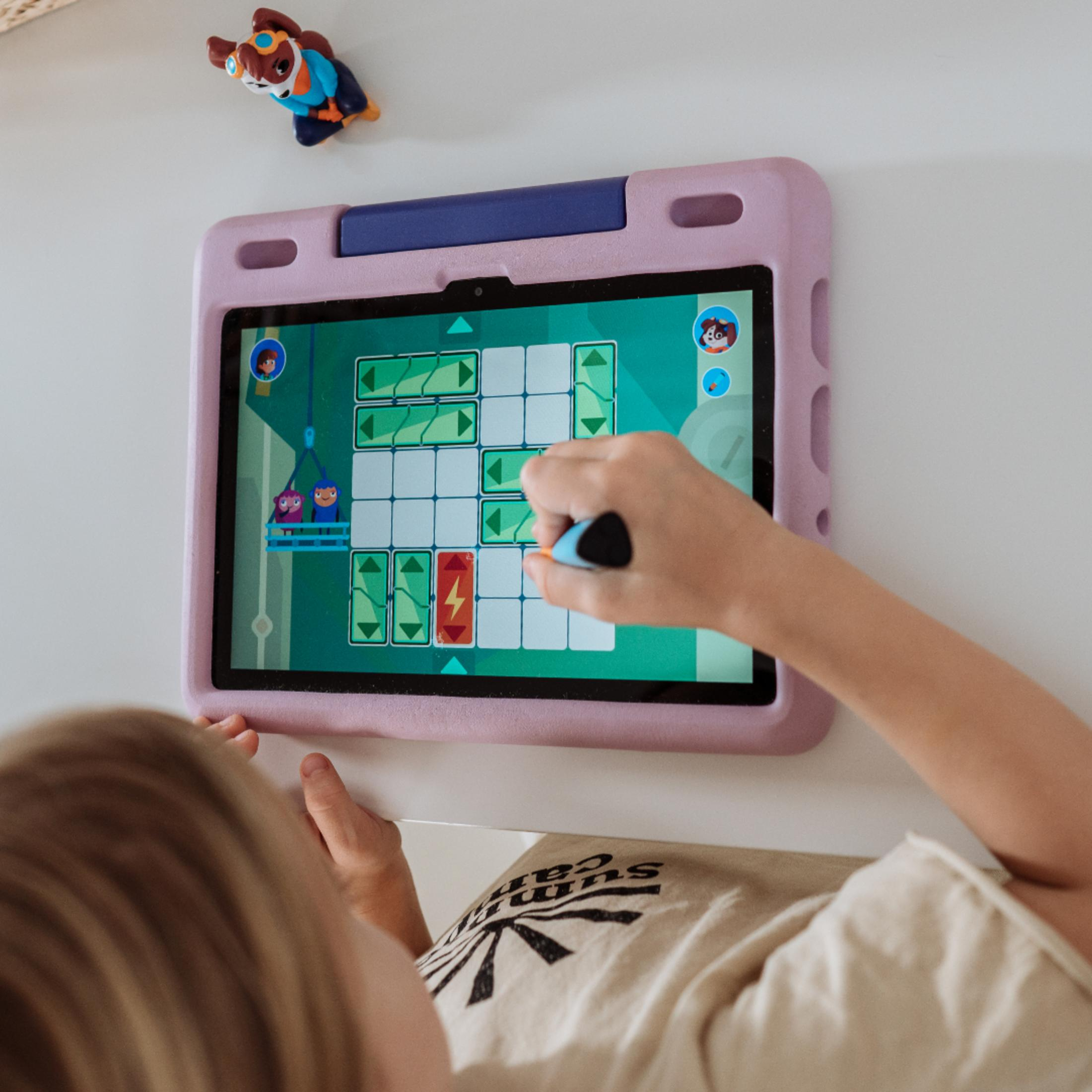 Ein Kind benutzt ein Tablet mit einem Spiel, mit einer kleinen Figur oben drauf.