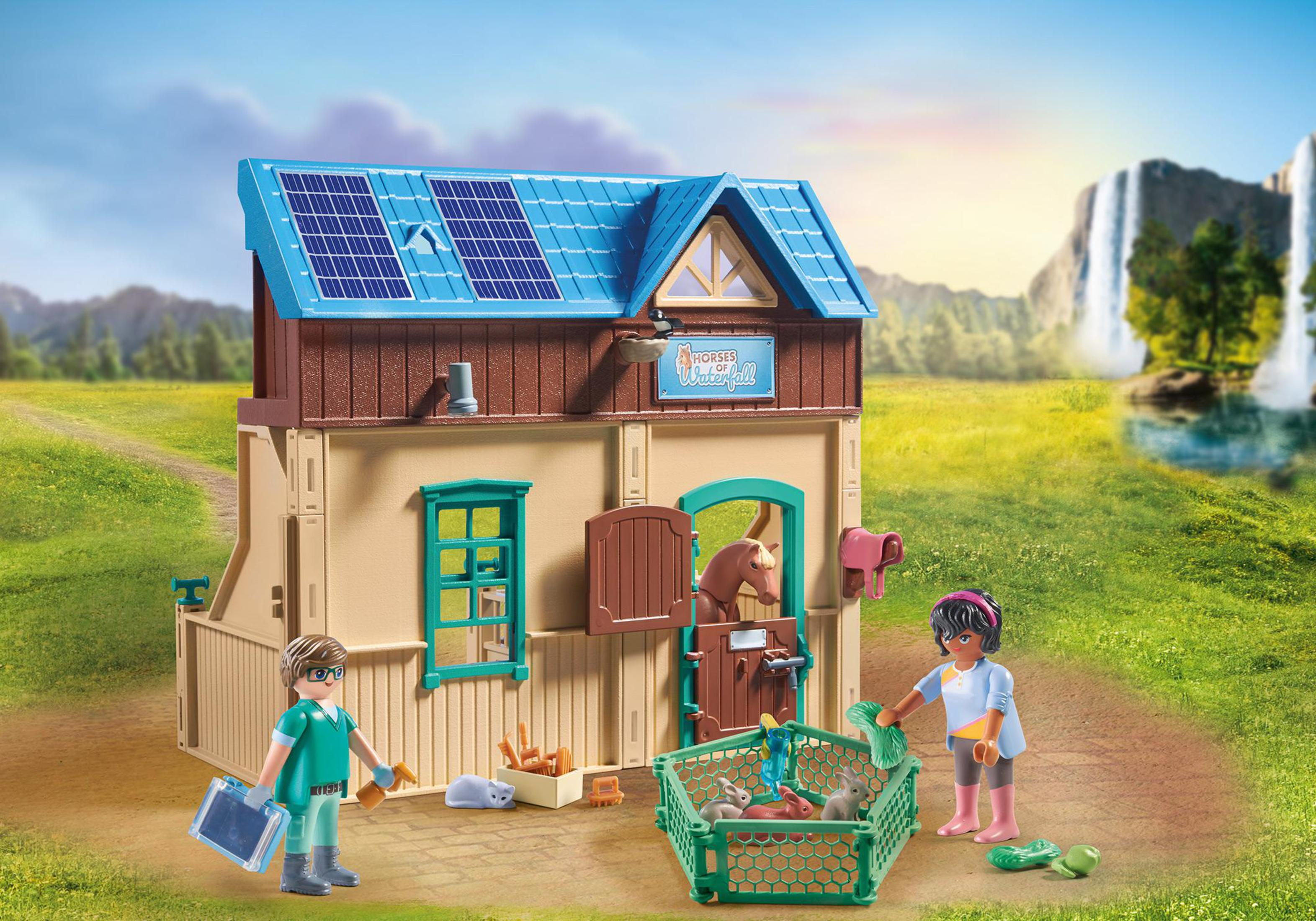 Una scena di stalla Playmobil con due figure e animali. Erba verde.