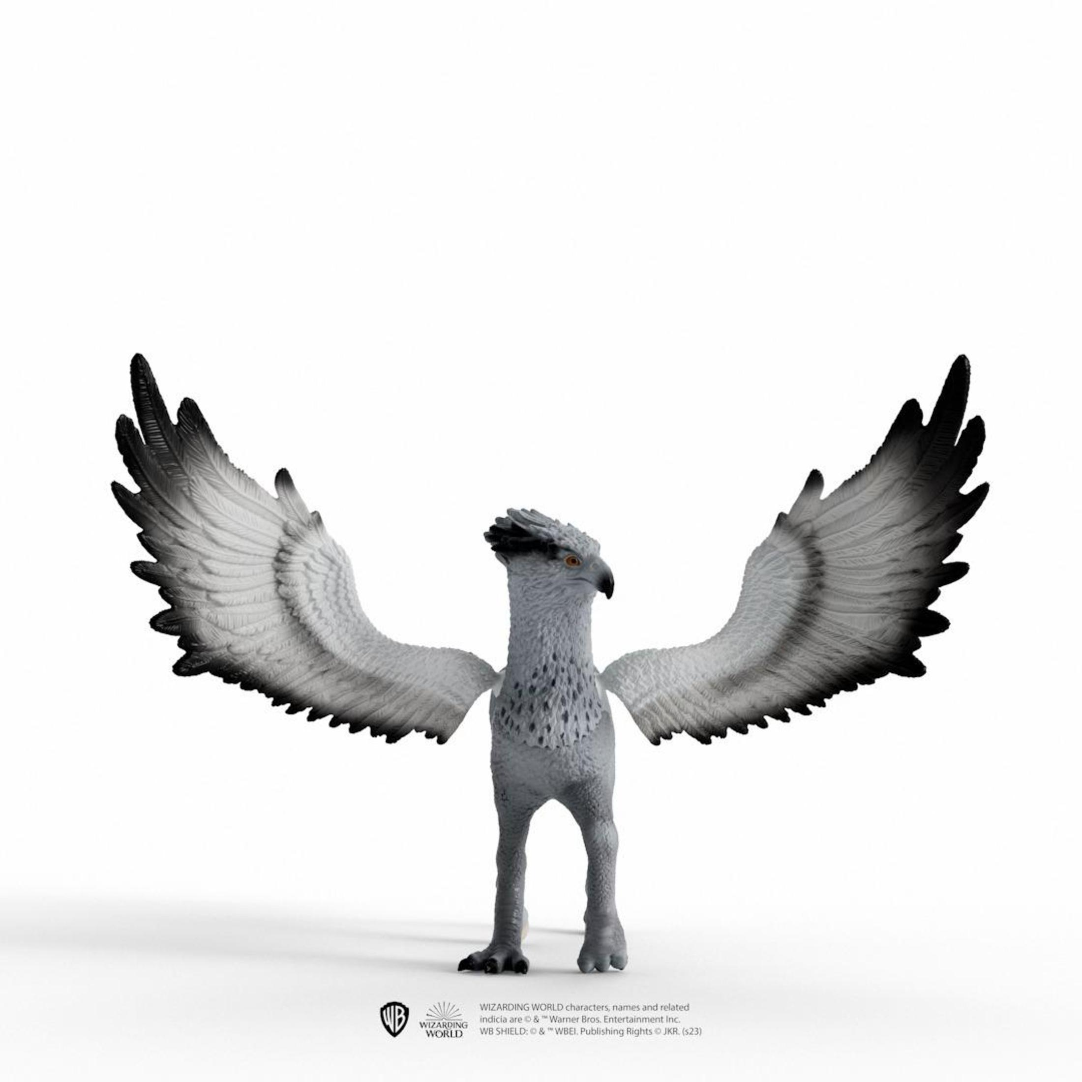 Una statuetta di un grifone con le ali spiegate, su una superficie bianca. Le sue ali sono grigie e nere.