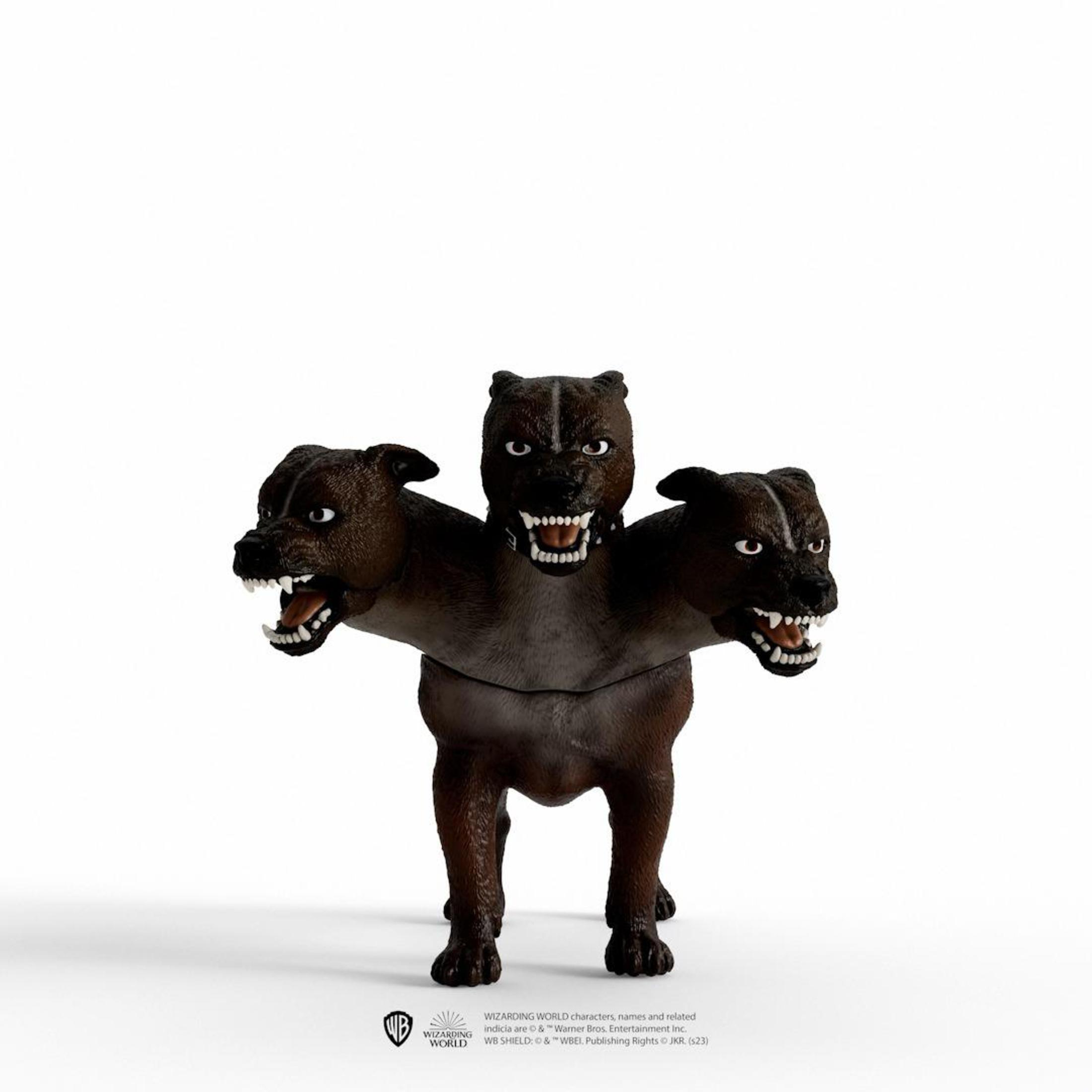 Zabawka w kształcie trójgłowego psa z otwartymi pyskami. Pies jest brązowy z białymi zębami, na białym tle.