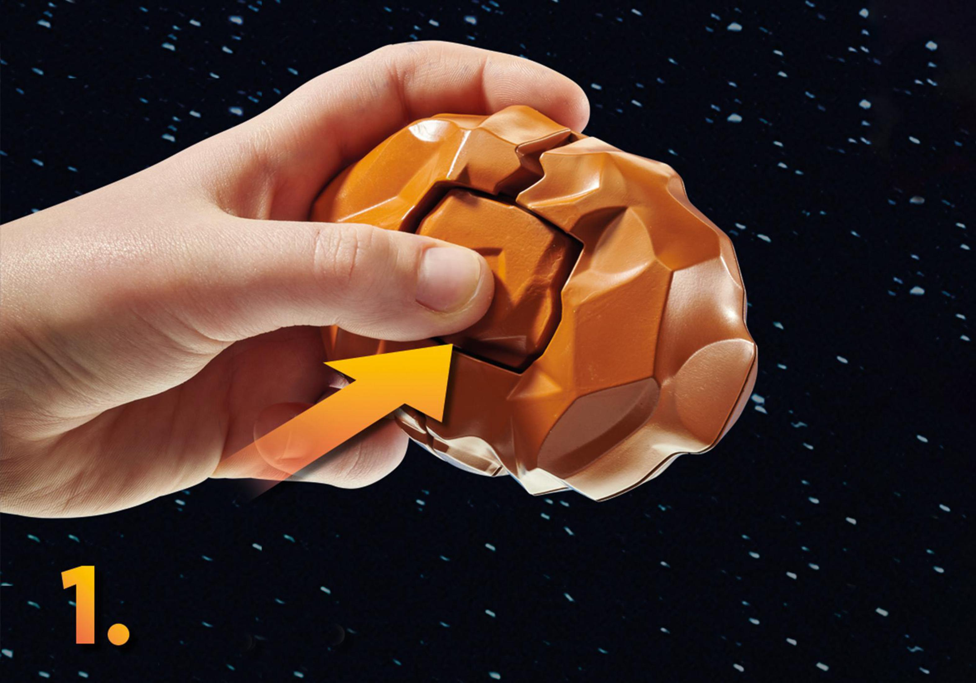 Eine Hand hält ein braunes Puzzleteil mit einem Pfeil. Es ist eine braune, felsige Form.