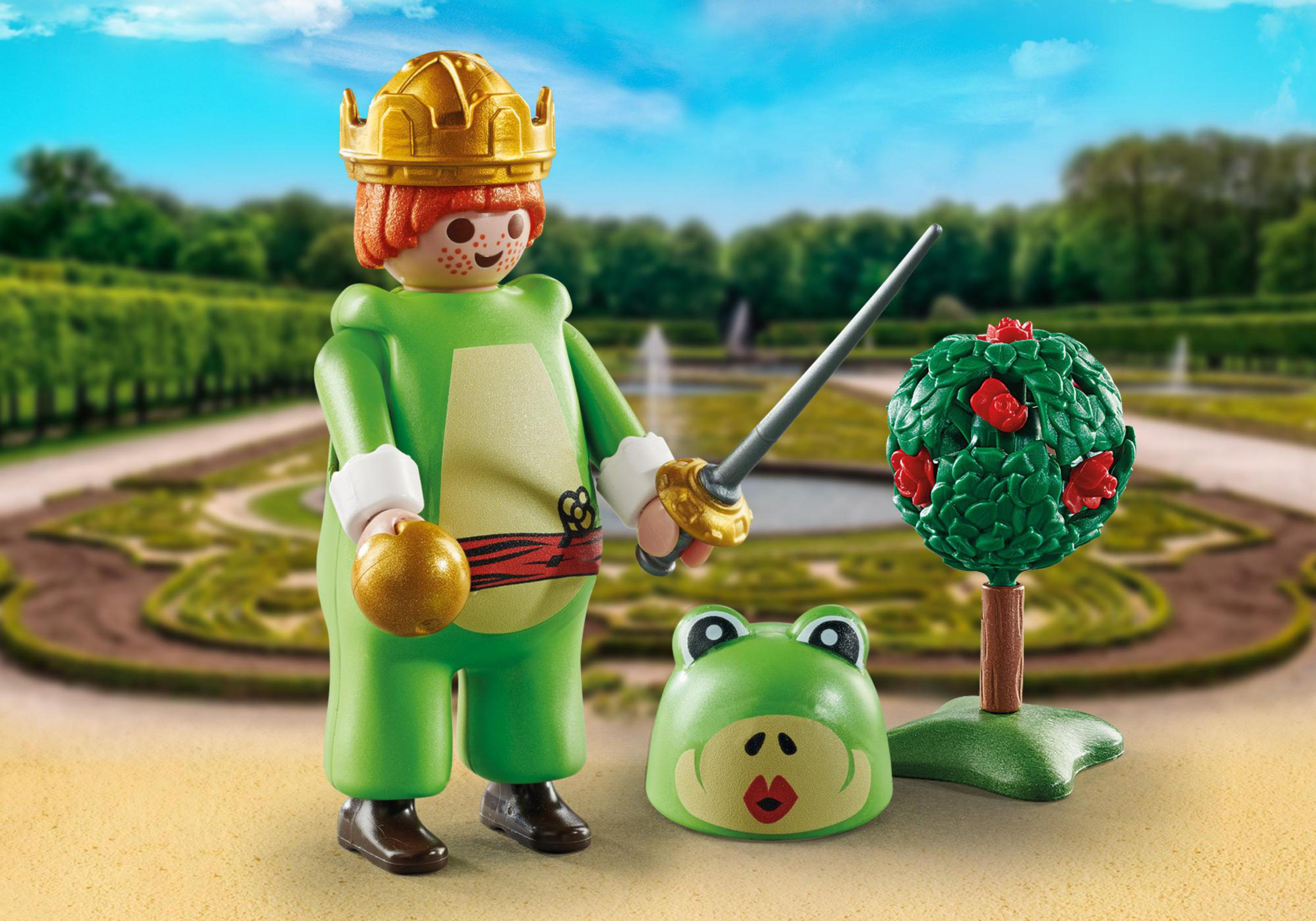 Spielzeugfigur eines grün gekleideten Königs mit Krone, Schwert und Froschmaske. Gartenhintergrund.