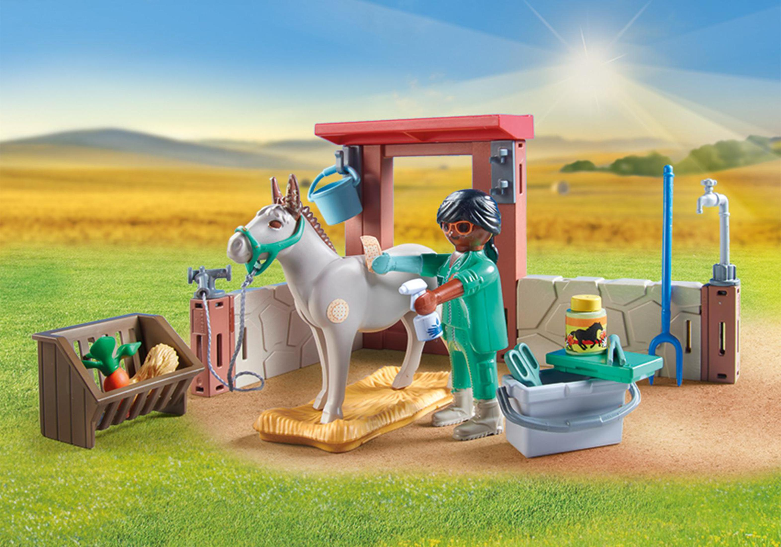 Un set Playmobil con un cavallo che viene lavato da una persona. Una stalla e provviste sono vicine.