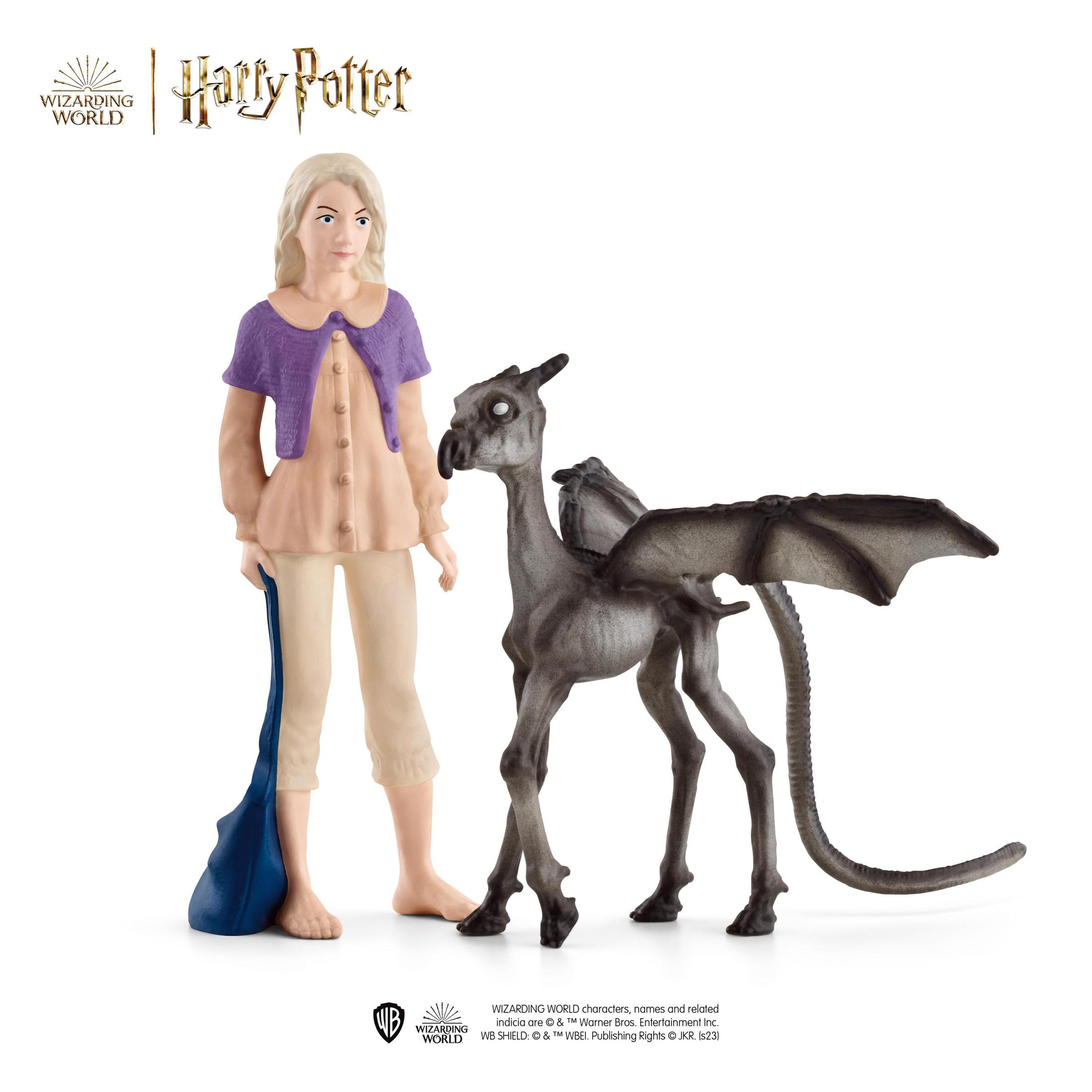 Una figura di Luna Lovegood e un giocattolo Kneazle grigio da Harry Potter, su una superficie bianca.