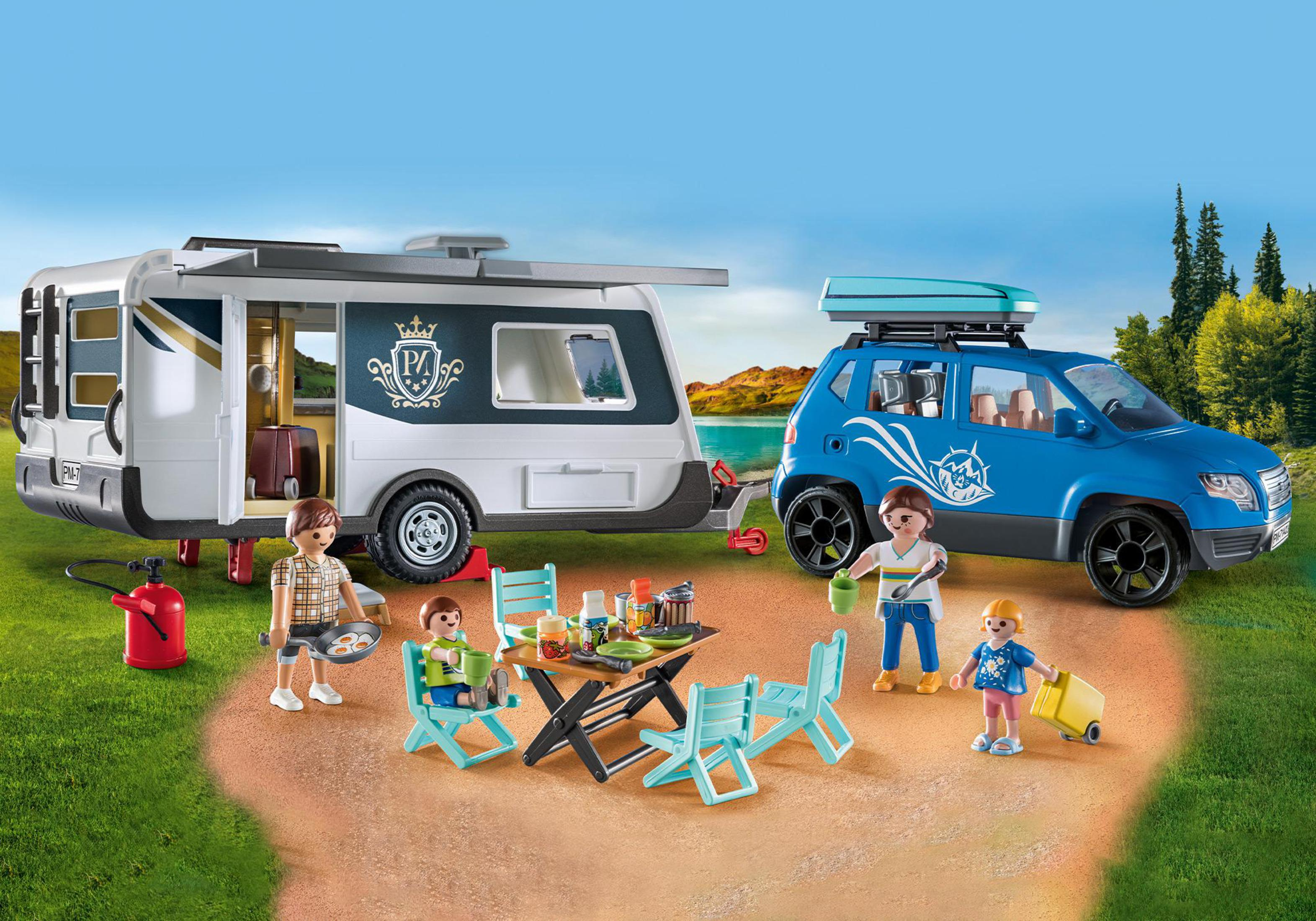 Spielzeug-Wohnwagen, Auto und Familie, die auf Gras am Wasser campen.